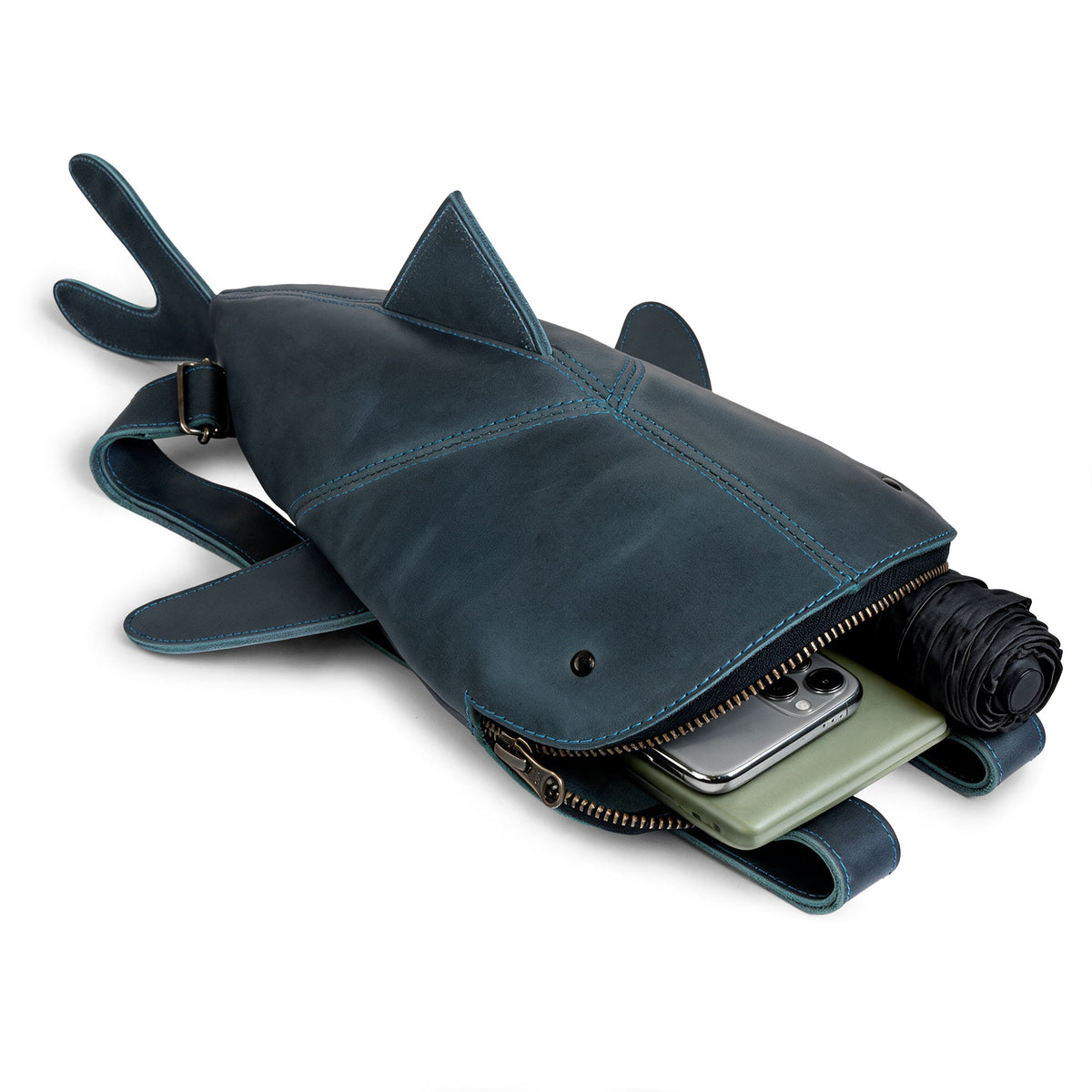 Open Hide & Drink Leather Shark Backpack (Megalodon) displaying space for a smartphone, rolled clothing, and everyday travel essentials. Leather Shark Backpack (Megalodon), Casual Bag, Messenger Bag, Travel Bag for Men and Women, Full Grain Leather, StockyardX, Small Batch Production, Hand Cut, Hand Sewn, Fire Branded, Artisan, Handmade in La Antigua Guatemala & Oaxaca Mexico.