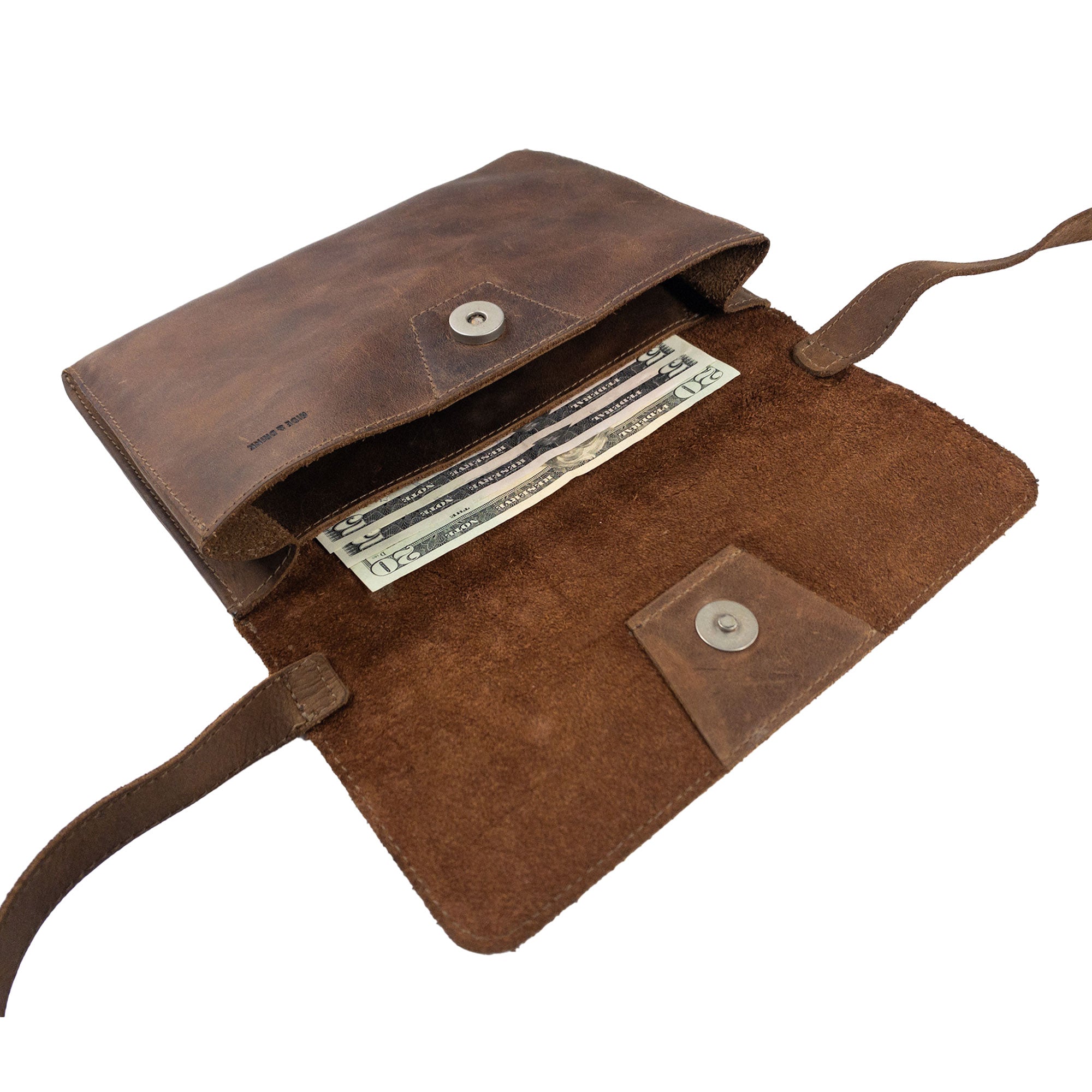 An open view of the inside of the Minimalist Shoulder Bag by Hide & Drink reveals organized space perfect for essentials. This Mini Classic Shoulder Bag, made from full grain leather, doubles as a rectangular messenger bag and is an excellent travel accessory. Handmade with care, this artisan piece is crafted through small batch production from La Antigua Guatemala & Oaxaca Mexico.