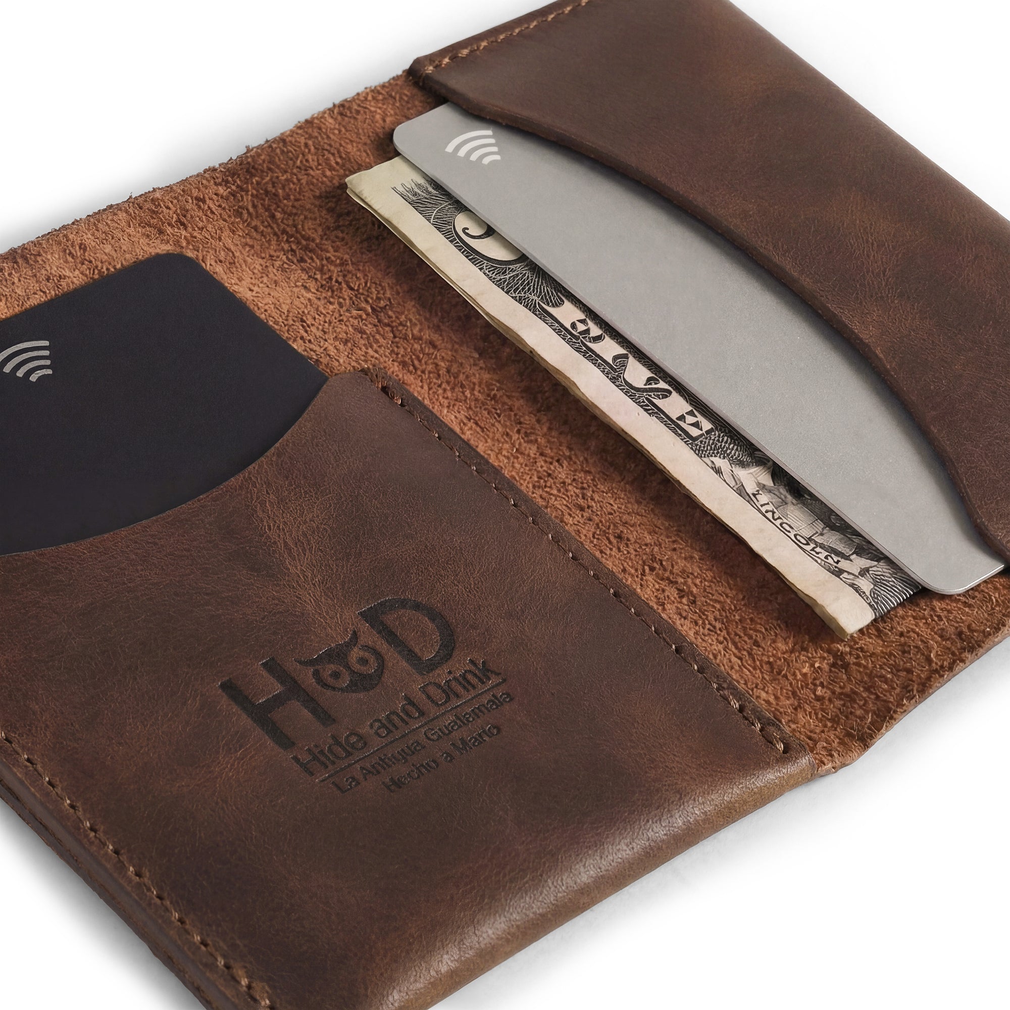 Inside view of Hide & Drink's Bifold Slim Card Holder with cards and cash neatly organized. This wallet harmoniously blends style with functionality, providing a minimalist design for credit card storage. Its full grain leather construction showcases artisan craftsmanship and is handmade in La Antigua Guatemala, making it a great money organizer.