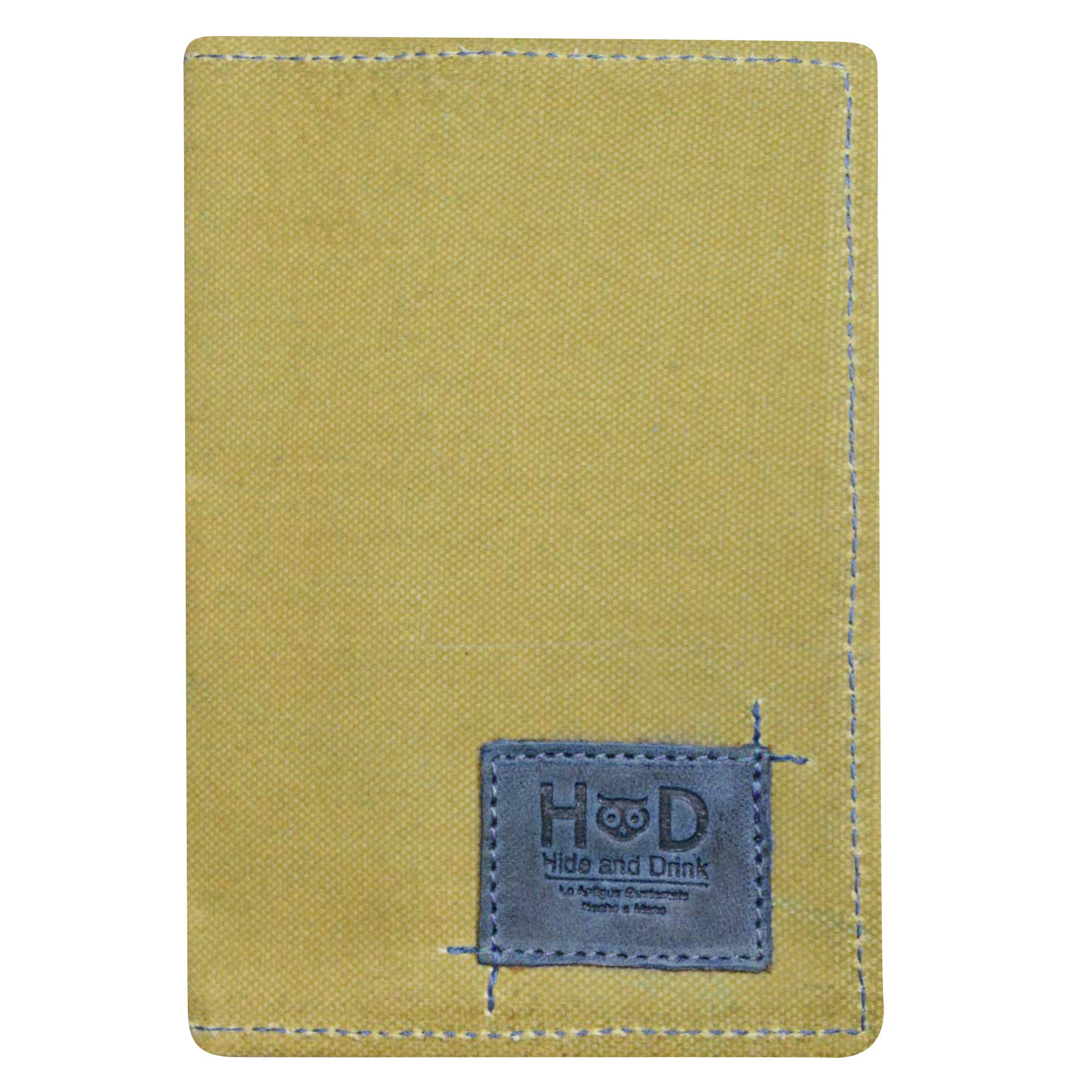 Hide & Drink Waxed Canvas Field Notes Cover resting on a textured background, highlighting its color and sturdiness. This artisan-crafted Wallet Case (3.5 x 5.5 in.) Journal Cover is ideal for anyone looking to keep their notes organized.