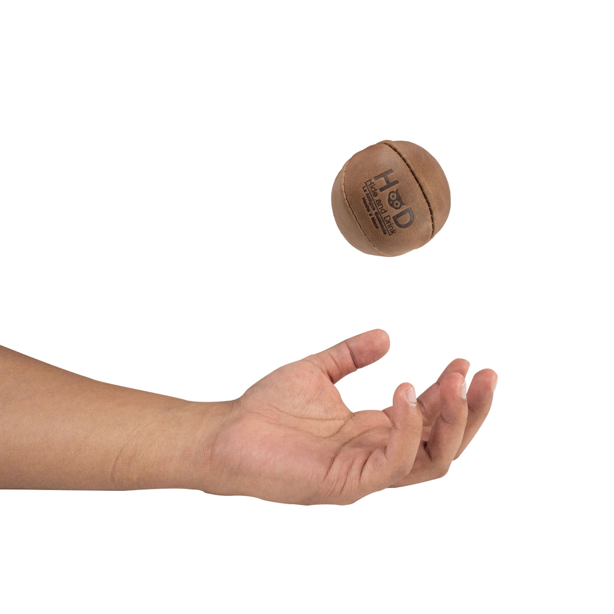 Hide & Drink brown Stress Ball caught mid-flight, excellent for relieving fidgeting and anxiety. This squishy tension accessory features a classic design crafted from durable full grain leather, handmade in La Antigua Guatemala.