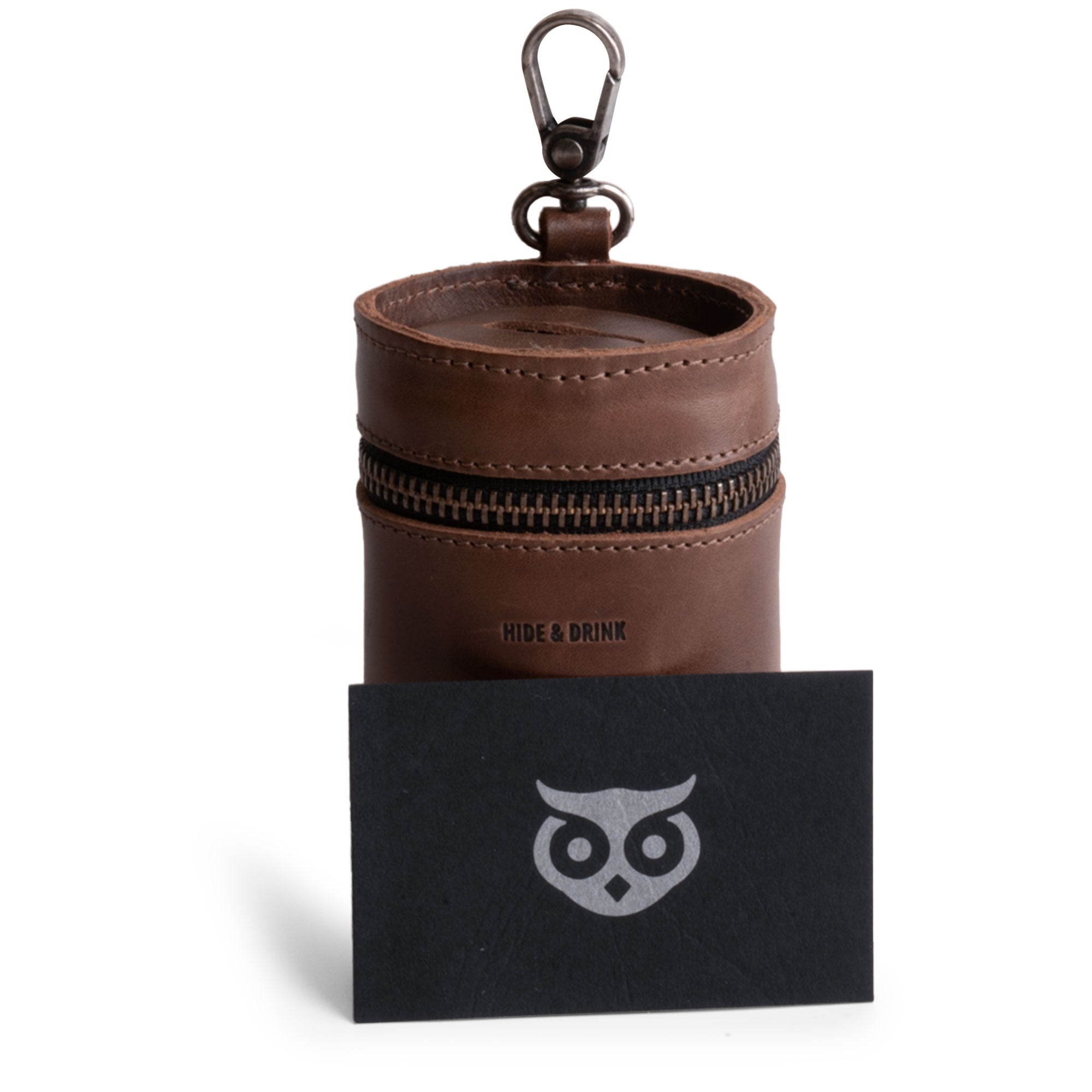 Hide & Drink's Bucket Coin Release alongside a brand card, highlighting the brand's craftsmanship. This full grain leather coin pouch serves as a men’s change purse, ideal for organizing coins and ensuring durability through artisan techniques.