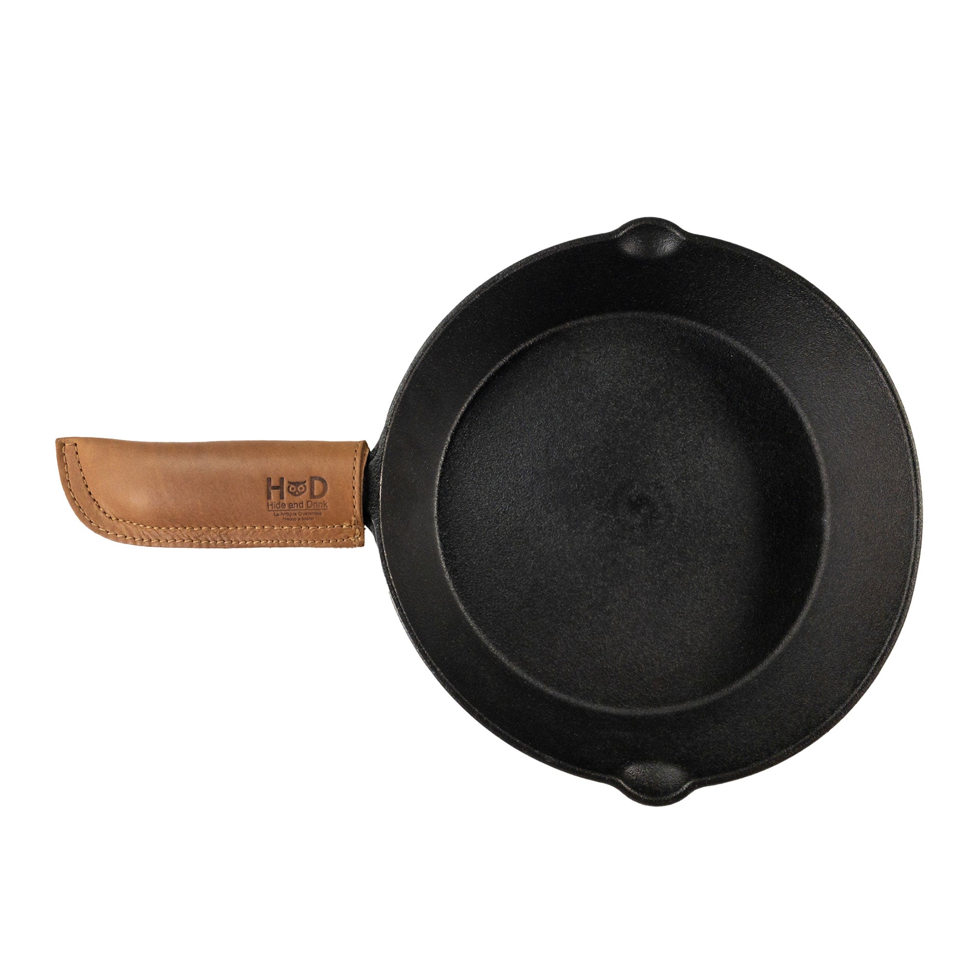 Hide & Drink Cast Iron Panhandle Cover featured against a clean background. This full grain leather hot handle protector is double stitched for enhanced durability and slides easily onto metal skillet grips. Artisan-made in La Antigua Guatemala & Oaxaca Mexico, it's perfect for adding flair to your cooking.