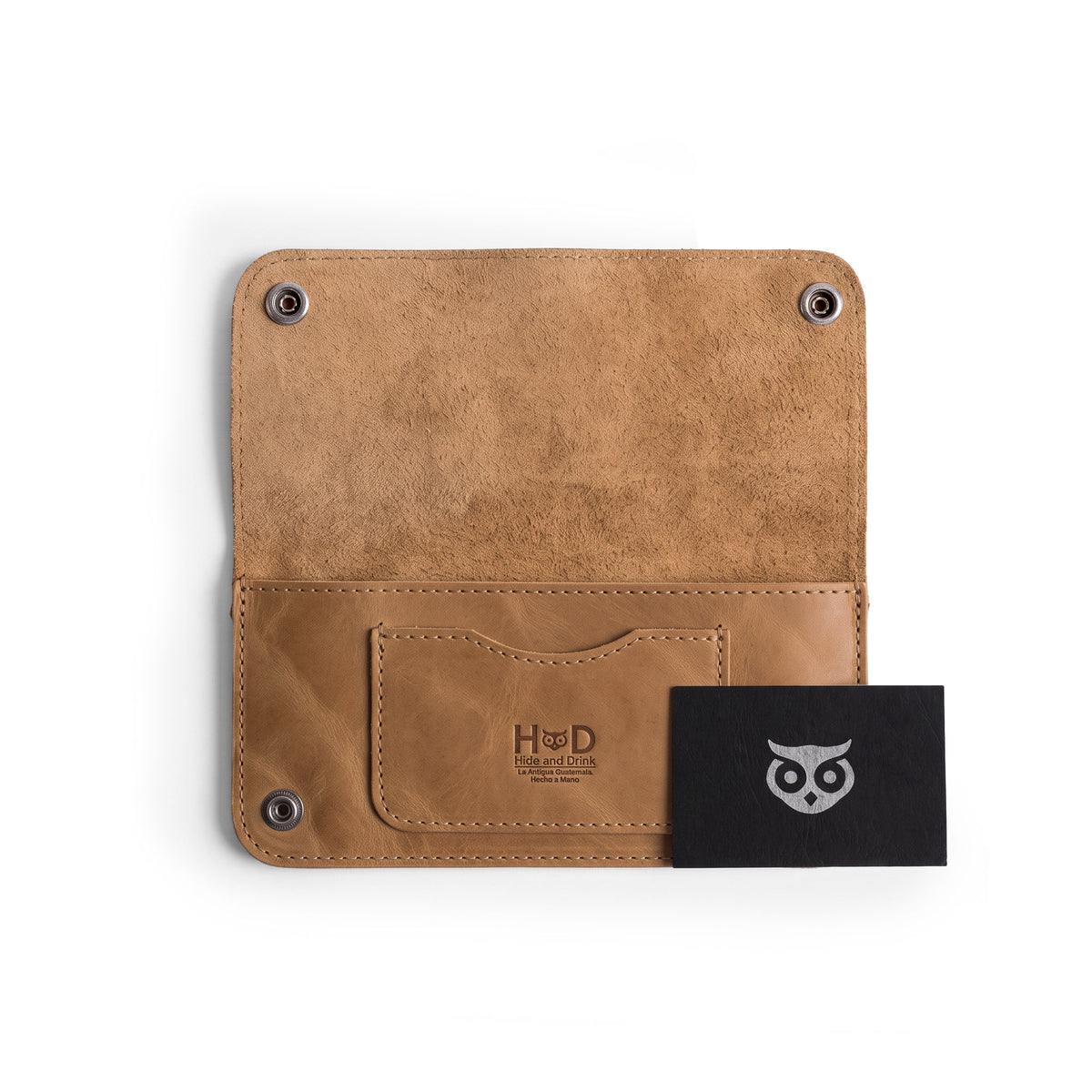 Detailed view of the Brown Double Snap Folio Wallet by Hide & Drink, showcasing its high-quality full grain leather texture. This accessory serves as a rectangular flat bill holder with card slot, ideal for a night bag or travel accessory. Artisanally crafted in La Antigua Guatemala & Oaxaca Mexico, representing the charm of small batch production.