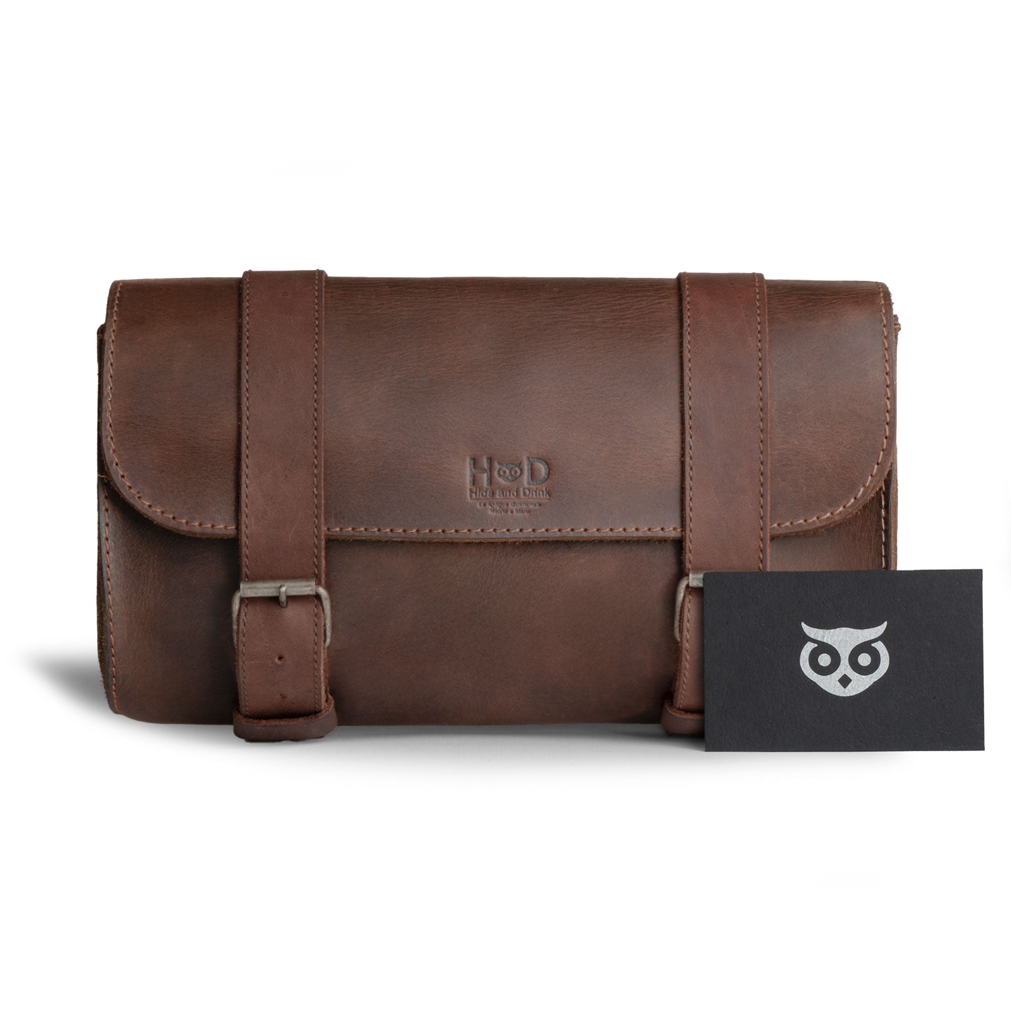 Hide & Drink Leather Motorcycle Tool Bag presented with a business card, featuring a sleek Full Grain Leather design, perfect for those seeking a minimalist Biker Bag for Tools and Essentials. This elegant Handlebar Bag with Adjustable Straps doubles as a Tool Organizer, reflecting dedication to Small Batch Production, Hand Cut, and Hand Sewn artistry from La Antigua Guatemala & Oaxaca Mexico.