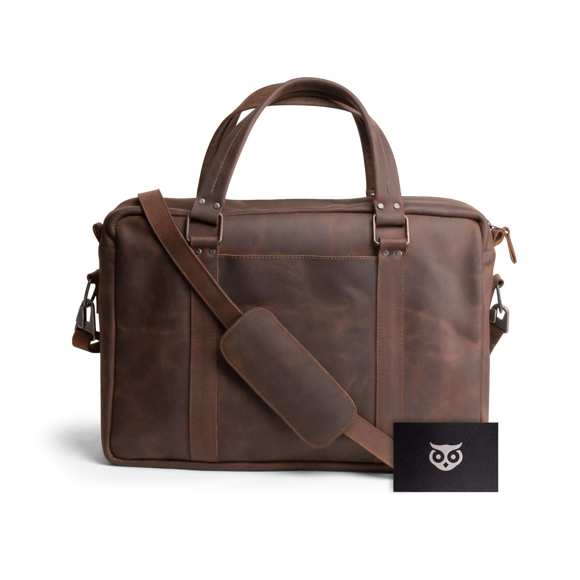 Classic Leather Briefcase by Hide & Drink, presented with its accompanying cards, embodying a sleek and professional look. Crafted from Full Grain Leather, this messenger bag features an adjustable shoulder strap and a durable water resistant lining, making it excellent for daily commuting. Handmade in La Antigua Guatemala, it reflects quality small batch production.