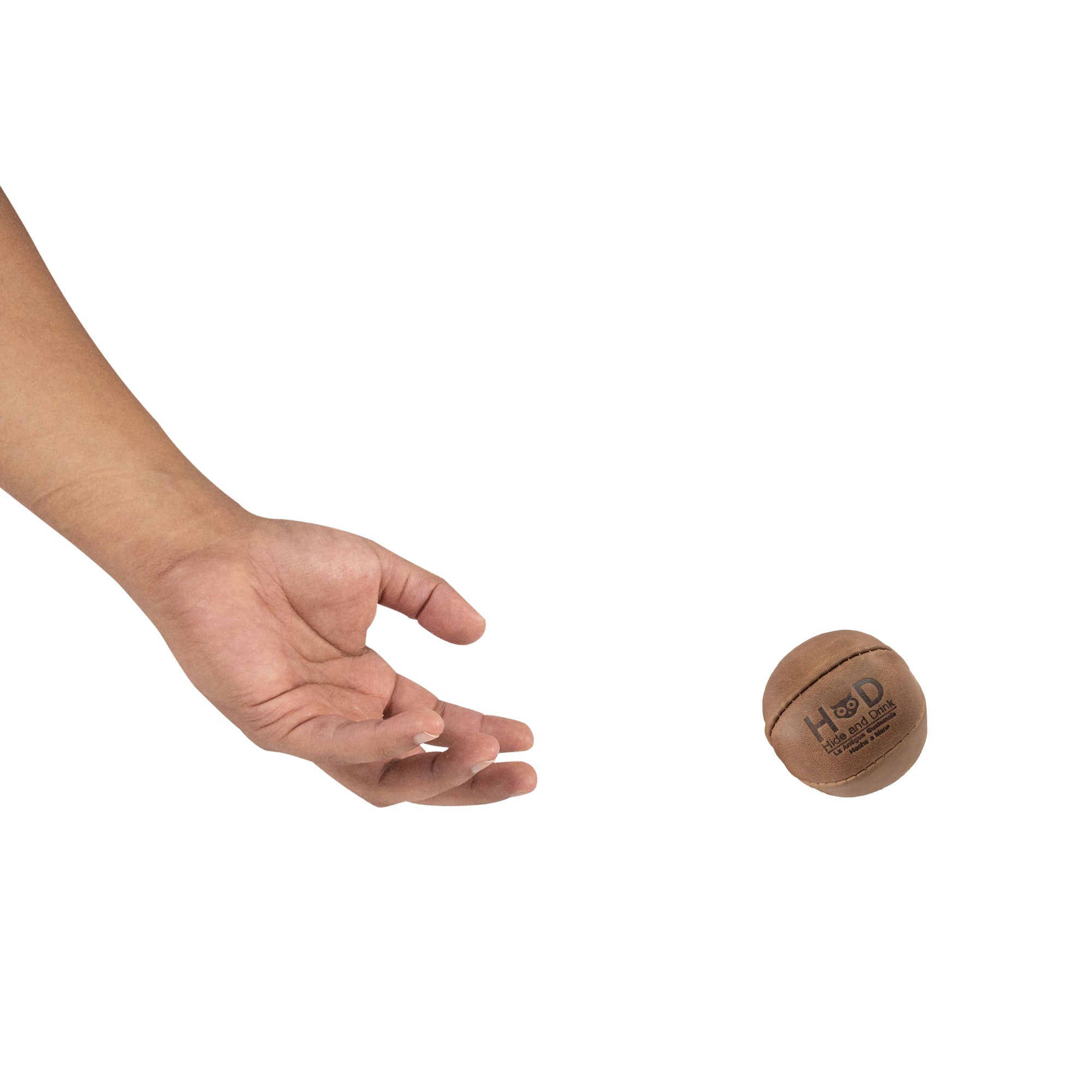 Hide & Drink brown Stress Ball released into the air, designed to alleviate fidgeting and anxiety. This squishy tension accessory showcases classic design, made from full grain leather, artisan crafted in La Antigua Guatemala.