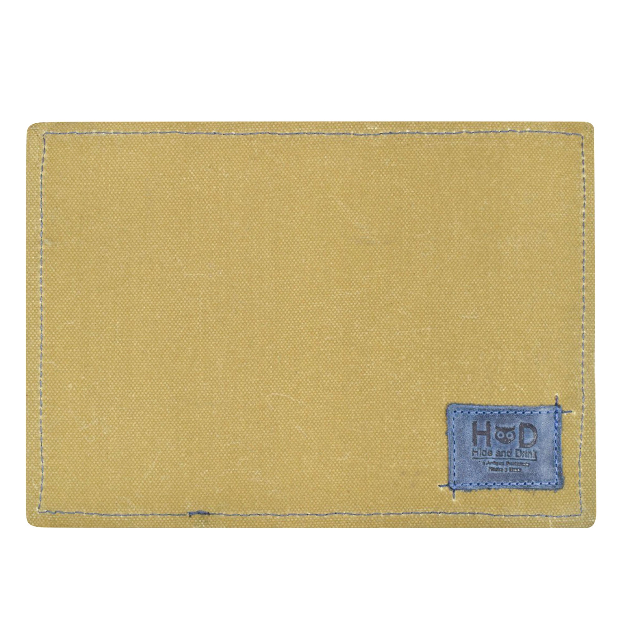 Back view of the Hide & Drink Waxed Canvas Field Notes Cover displayed on a table, showcasing its craftsmanship and durability. Ideal for travelers, this versatile Wallet Case (3.5 x 5.5 in.) Journal Cover doubles as a pocket organizer for essential items.