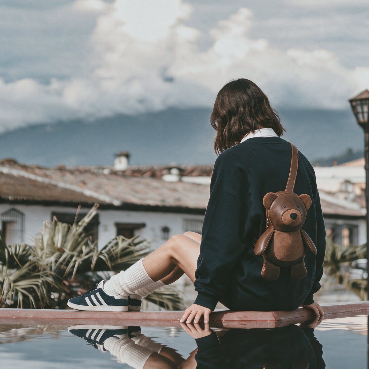 Lifestyle view of a person wearing the Tudi Frudi Leather Teddy Bear Crossbody Bag as a cute brown bear backpack, featuring an Adjustable Shoulder Strap and versatile Messenger Bag, Shoulder Bag, Zippered Sling Bags, Travel Backpack, Purses for Men and Women, and Satchel styling in Full Grain Leather by StockyardX, made with Small Batch Production, Hand Cut, Hand Sewn, Fire Branded, Artisan, Handmade in La Antigua Guatemala & Oaxaca Mexico.