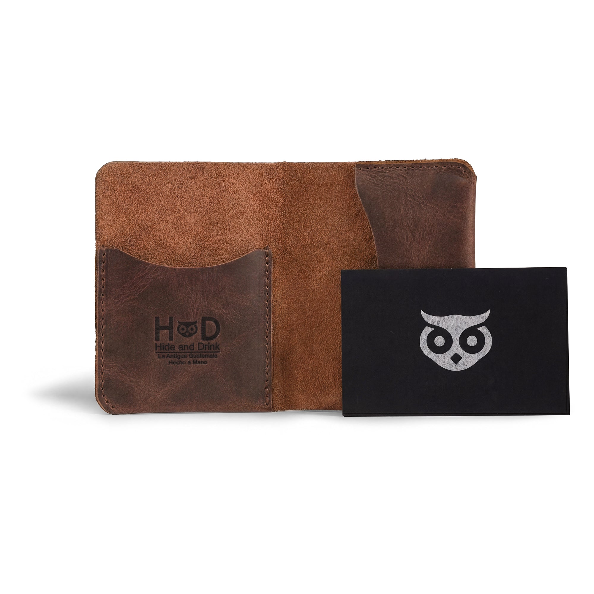 The Bifold Slim Card Holder from Hide & Drink displayed with accessories like a keychain and card, highlighting its stylish functionalities. This full grain leather wallet serves as a robust credit card storage solution and money organizer, emphasizing small batch production from artisans in La Antigua Guatemala.