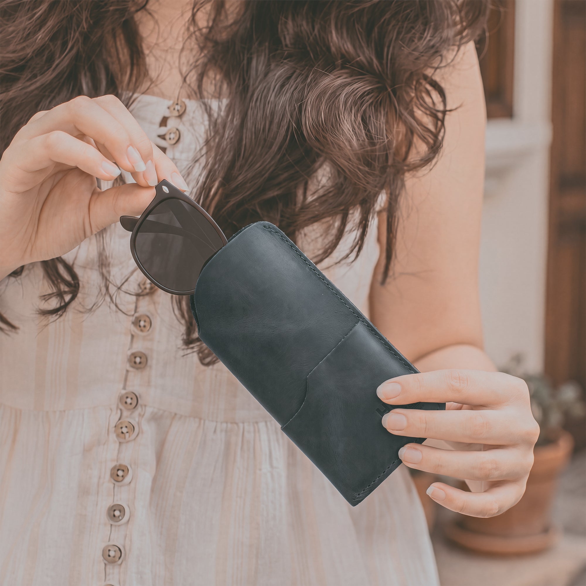 The Hide & Drink Sunglass Case & Wallet depicted in its practical use. This Rustic Sunglasses Case & Wallet, made from premium Full Grain Leather, serves as an essential eyeglasses sleeve for travel, expertly crafted in La Antigua Guatemala & Oaxaca Mexico.