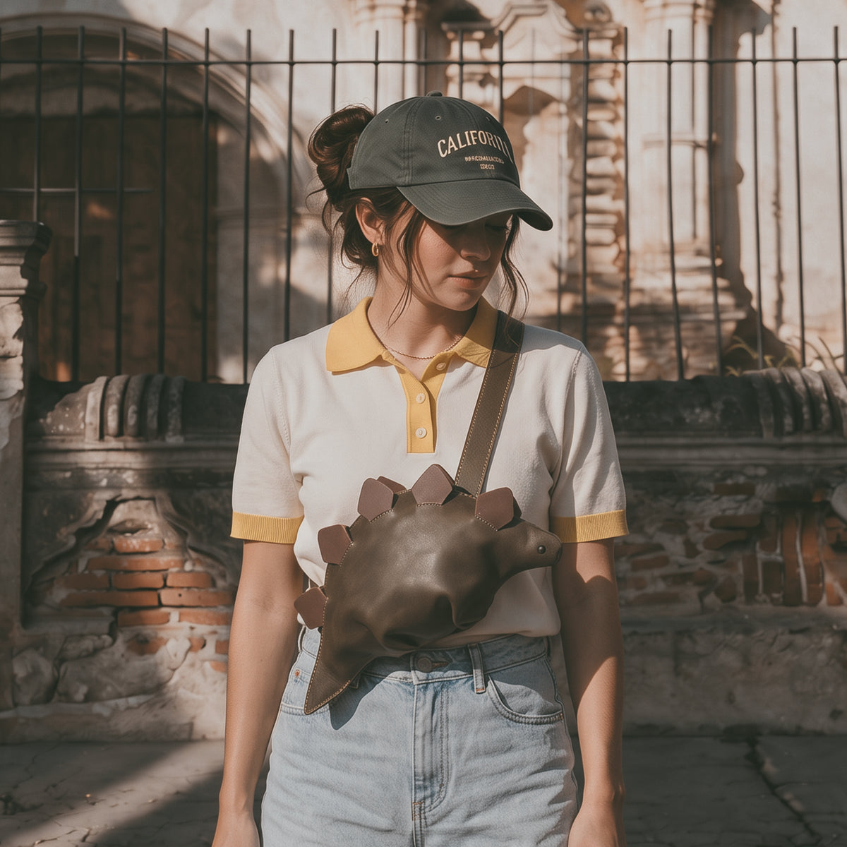 Model wearing the Tudi Frudi Leather Dinosaur Stegosaurus Crossbody Jurassic Bag as a Shoulder Bag, showcasing its Full Grain Leather design, Small Batch Production, Hand Cut and Hand Sewn Artisan craftsmanship, Fire Branded details by StockyardX, Handmade in La Antigua Guatemala & Oaxaca Mexico.