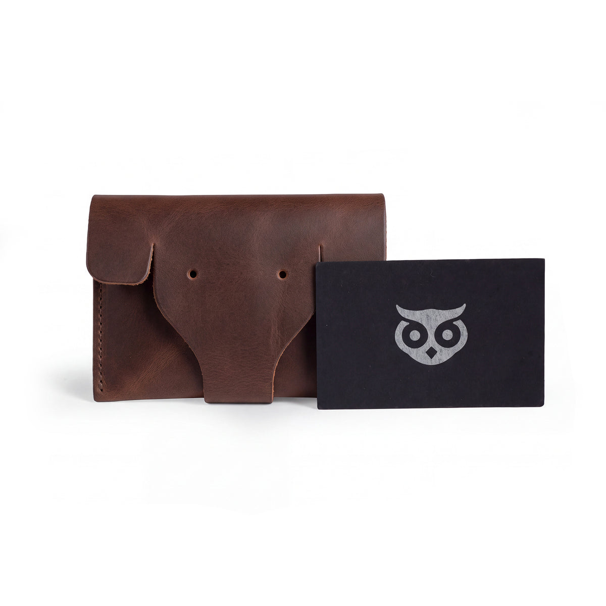 Elephant Coin Pouch by Hide & Drink alongside a business card, highlighting its compact and artistic design made from premium full grain leather. Card Pouch Elephant/Coin & Folded Bills/Wallet/Cable Holder/USB/SD/Change, Full Grain Leather, StockyardX, Hand Cut, Hand Sewn, Fire Branded, Artisan, Handmade in La Antigua Guatemala & Oaxaca Mexico.