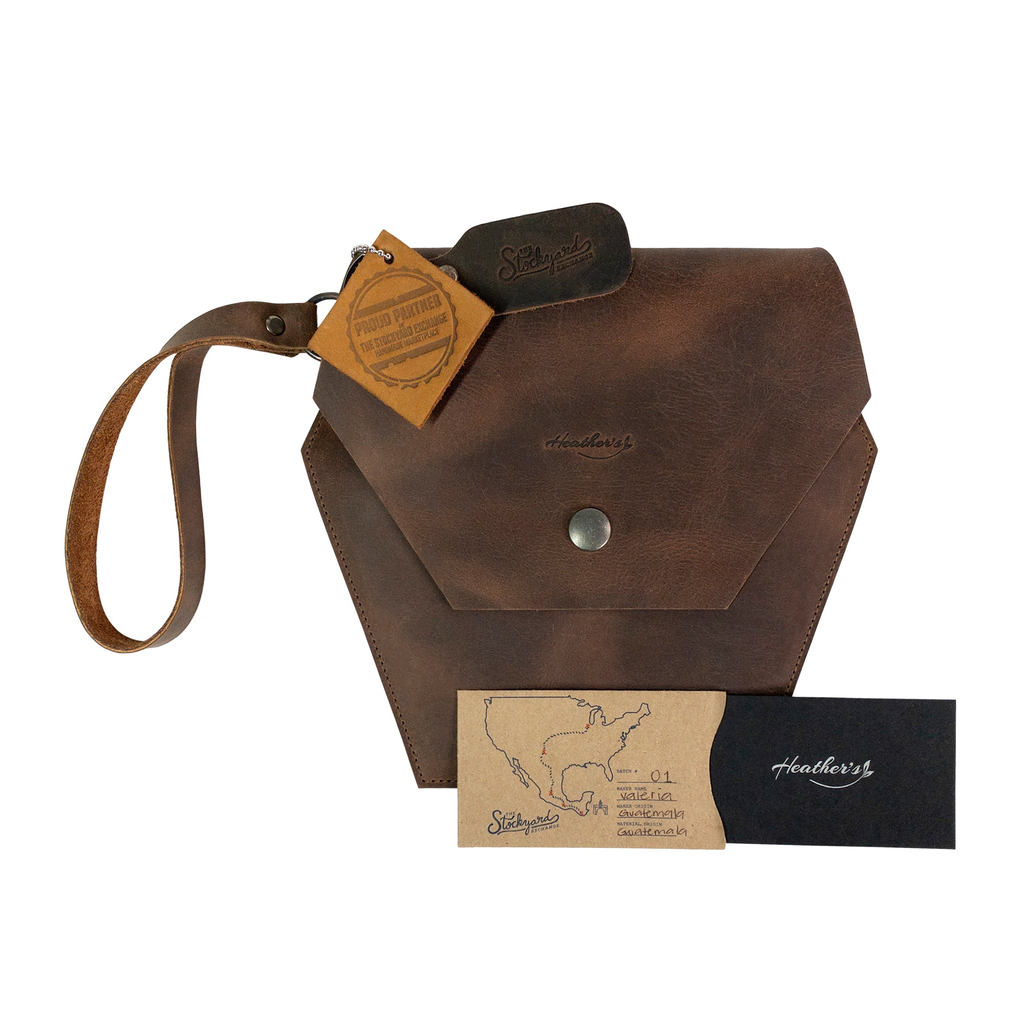 Heather's Hexagonal Clutch Bag package featuring the bag and care instructions. Perfect as a gift, this stylish bag serves as a travel handbag for makeup and toiletry items, crafted from Full Grain Leather. Each item showcases the artisan craftsmanship from La Antigua Guatemala & Oaxaca Mexico.