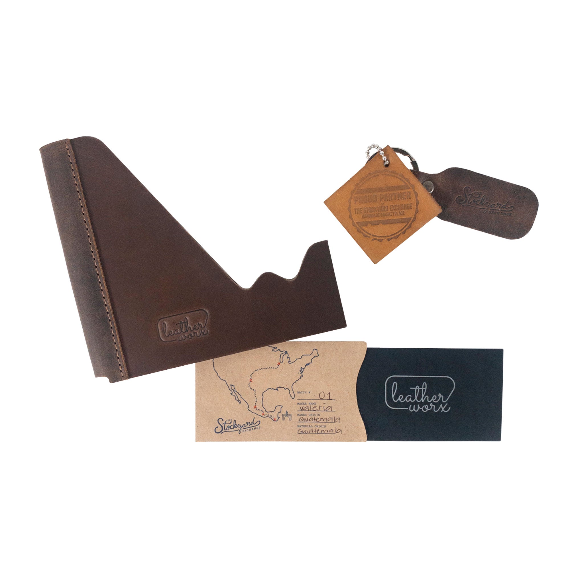 A stylish presentation of the Leather Worx Cell Phone Stand for Desk along with its packaging, highlighting the artisan connection with La Antigua Guatemala & Oaxaca Mexico. This rustic Cell Phone Holder functions as a versatile office accessory made from full grain leather, part of small batch production, complete with hand cut, hand sewn, and fire branded details.