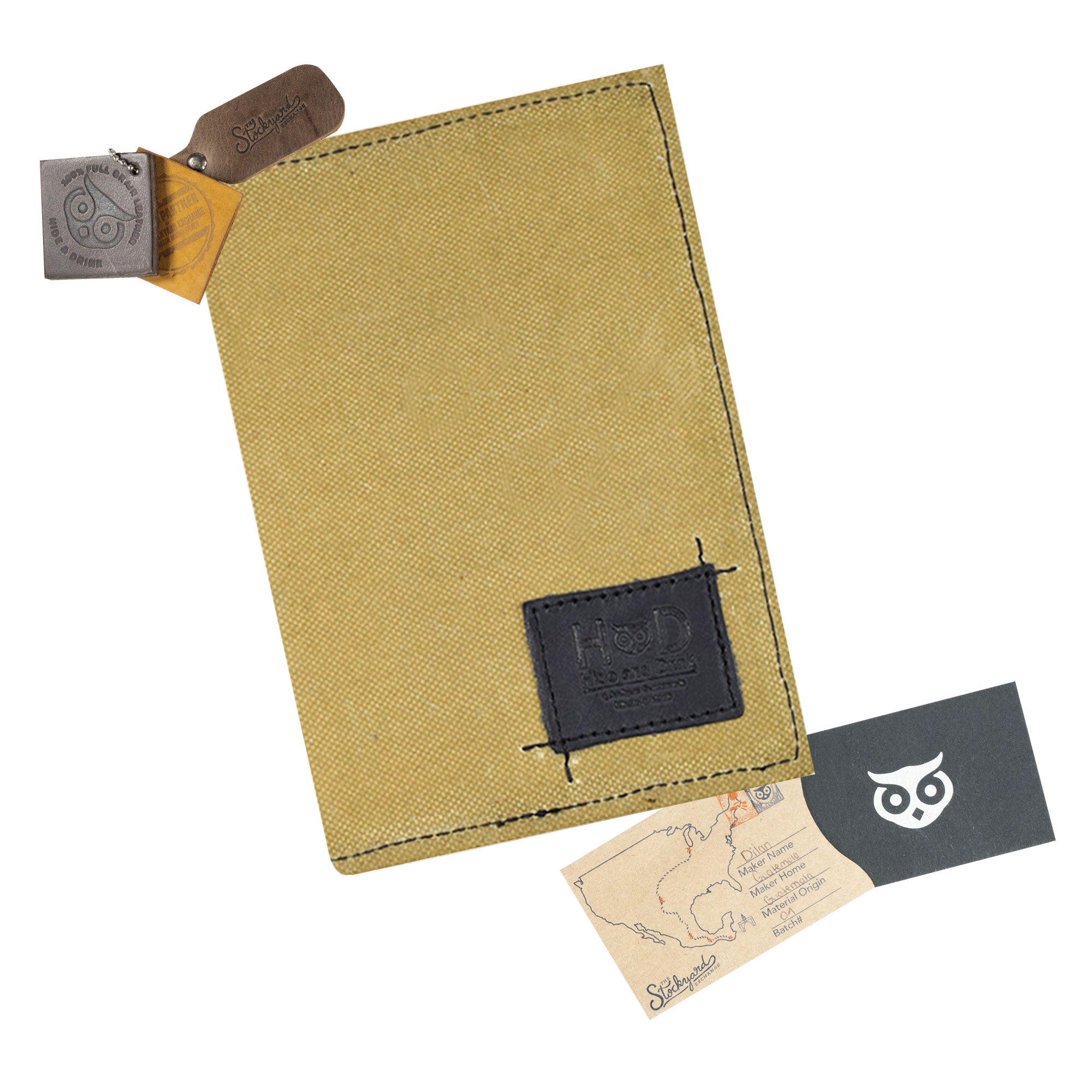 The Hide & Drink Waxed Canvas Field Notes Cover elegantly positioned, highlighting its detailed stitching and unique design. This practical journal cover serves multiple functions, making it an essential for every traveler and organizer.