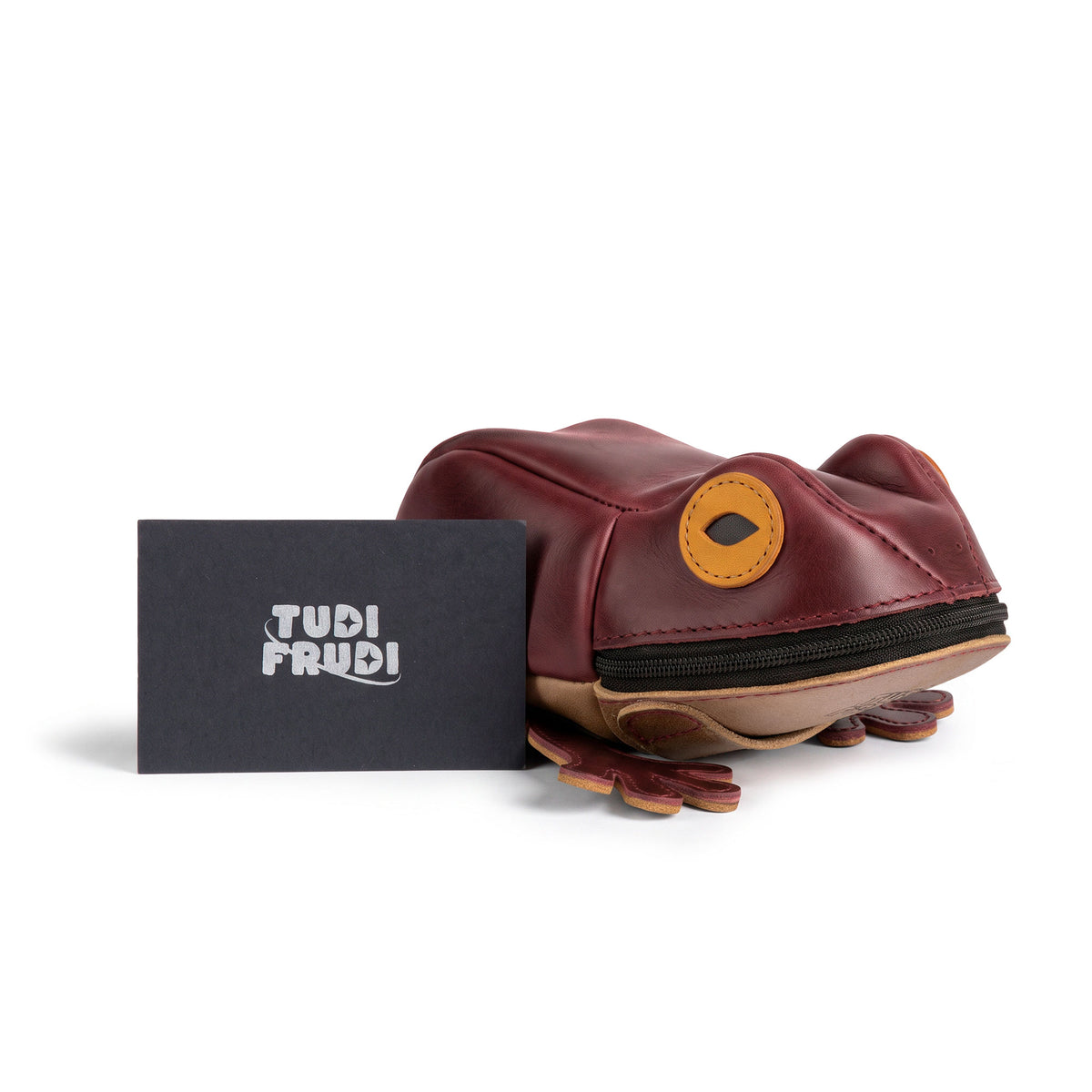 Tudi Frudi Frog Pouch shown beside branded packaging in a product showcase, highlighting the playful Frog-Shaped Pouch design and Full Grain Leather finish. Use it as a Cable Organizer, Small Accessory Case, Zippered Cash Holder Wallet for Coins, or Change Purse; ideal Pouches for Men and Women. Created through StockyardX Small Batch Production with Hand Cut, Hand Sewn, Fire Branded, Artisan craftsmanship, Handmade in La Antigua Guatemala & Oaxaca Mexico.