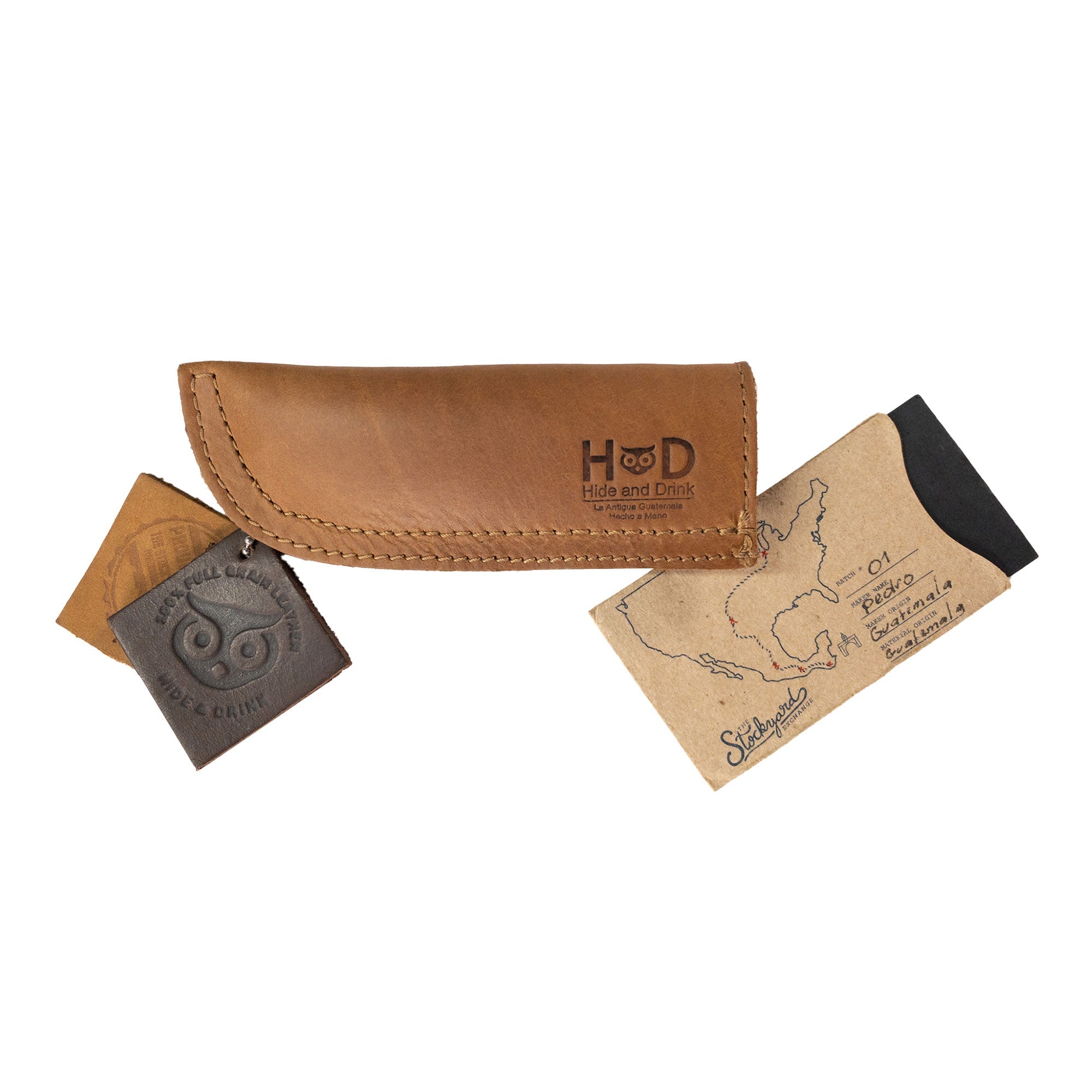 Hide & Drink Cast Iron Panhandle Cover elegantly displayed on a metal skillet. As a hot handle protector, it's designed to easily slide on and off, crafted from double layered full grain leather. Artisan-made in La Antigua Guatemala & Oaxaca Mexico, this piece adds functionality and style to your kitchen.