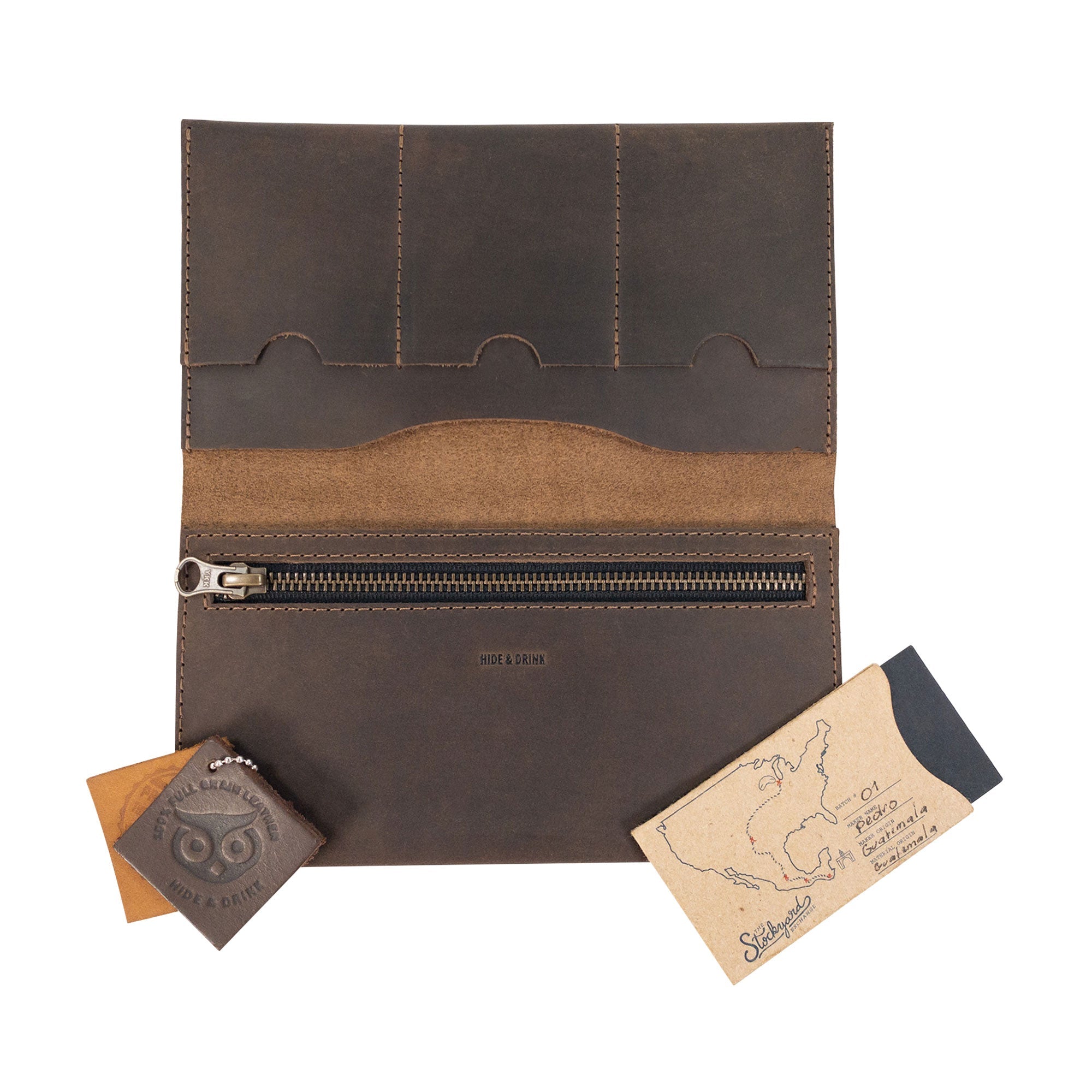 Flat lay of the Hide & Drink Large Wallet for Passport with Credit Card Slots, with leather tools beside it, emphasizing the artisan quality and small batch production from La Antigua Guatemala & Oaxaca Mexico.