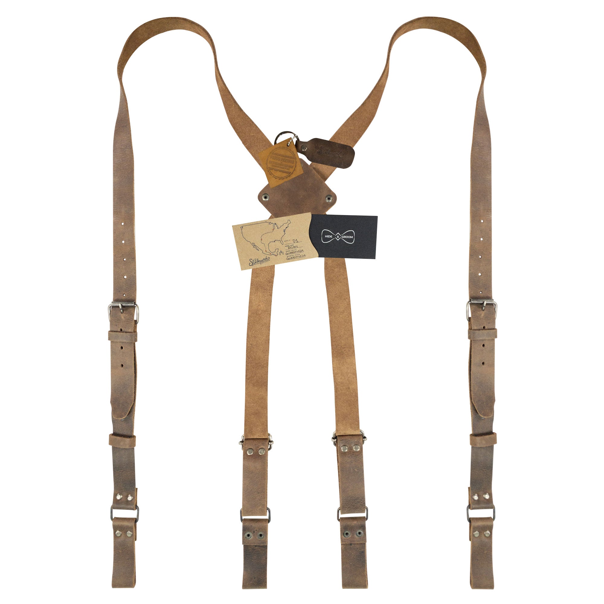 X Back Suspenders with Belt Loops from Hide & Groom, displayed with authenticity tags. Made from Full Grain Leather, these are perfect Broom Accessories for weddings and formal events. Each piece is handmade in La Antigua Guatemala & Oaxaca Mexico, showcasing quality craftsmanship in small batch production.