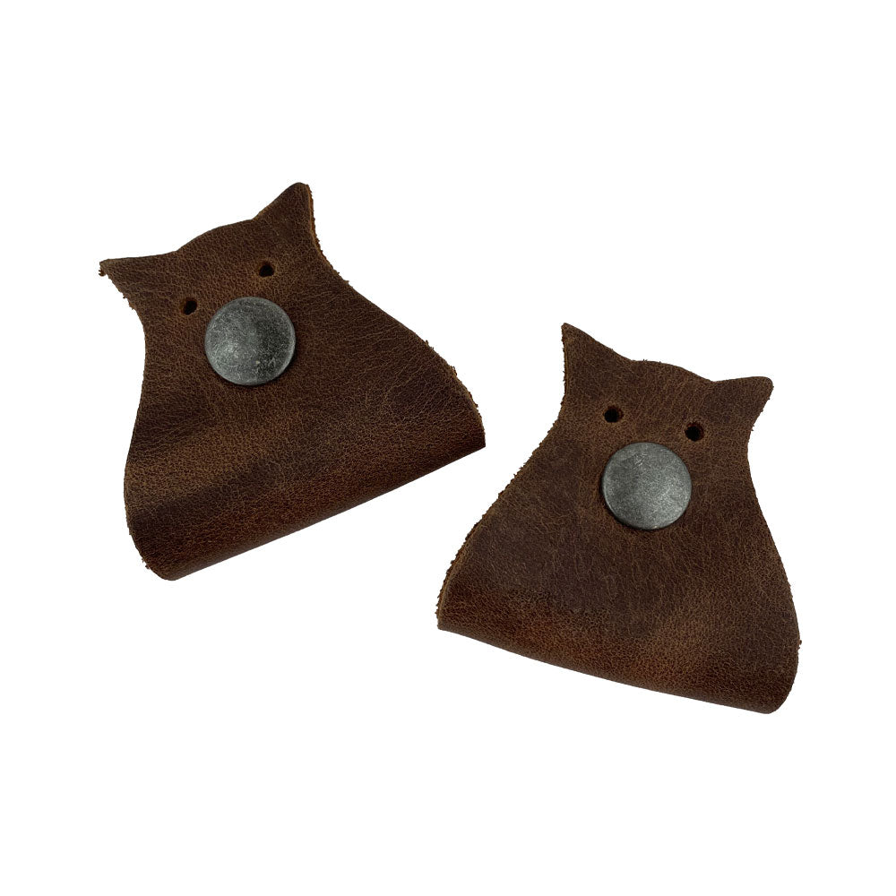 Owl Shaped Cord Keeper (2-Pack) by Hide & Drink emphasizing its quality leather and design for neat organization of cables. Owl Shaped Cord Keeper (Cord Clam) 2-Pack. Full Grain Leather, StockyardX, Small Batch Production, Hand Cut, Hand Sewn, Fire Branded, Artisan, Handmade in La Antigua Guatemala & Oaxaca Mexico.