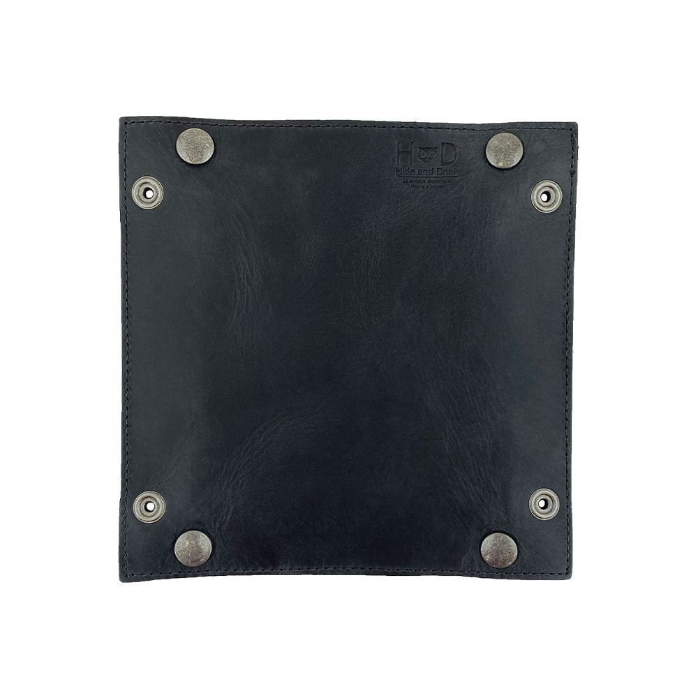 A close-up of the bottom side of the Valet Tray with Sheep Skin by Hide & Drink, highlighting the sturdy brass snaps that contribute to its functionality. This tray is perfect for organizing personal items like change and keys, handcrafted from Full Grain Leather & Sheepskin, showcasing the artisan workmanship from La Antigua Guatemala & Oaxaca Mexico.