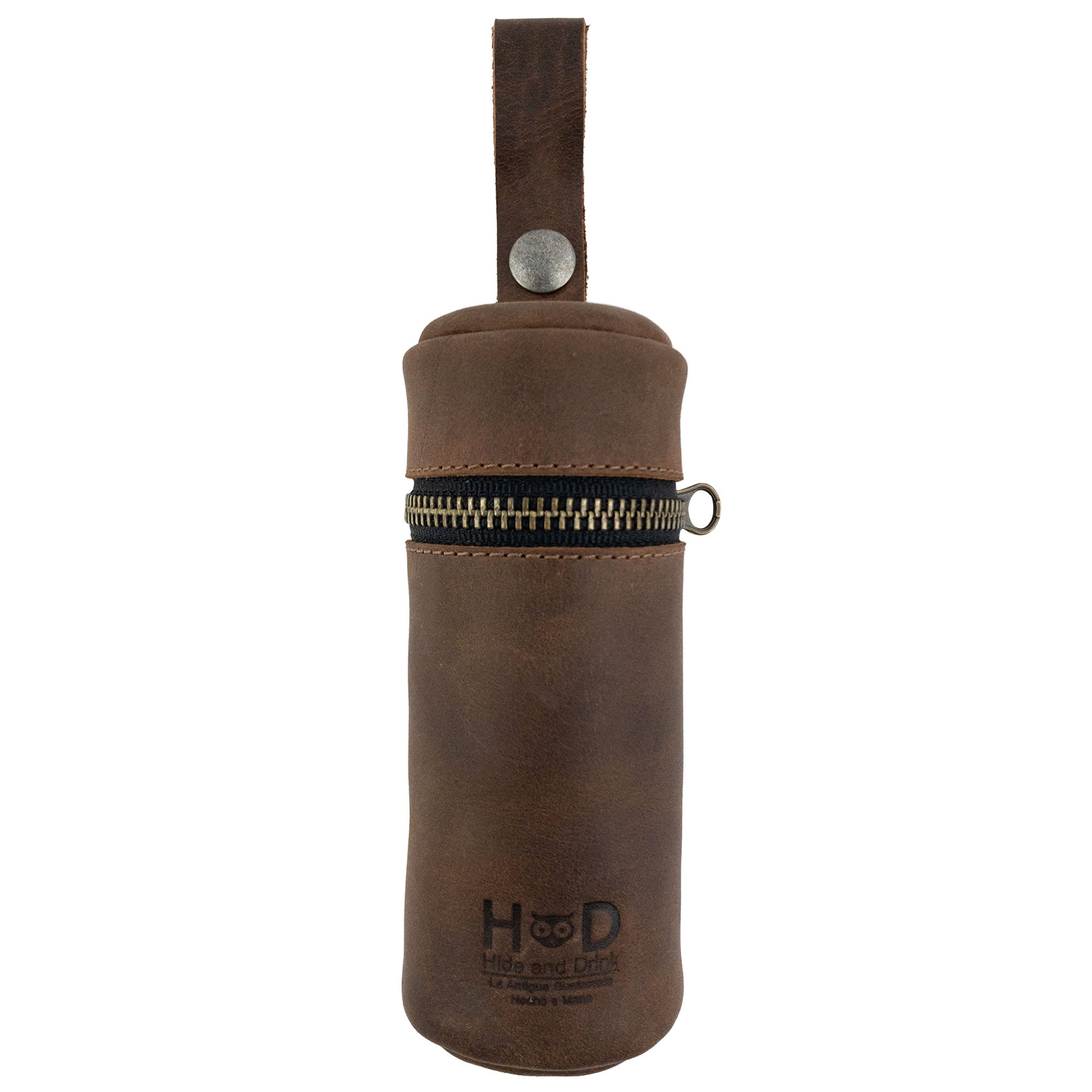 Hide & Drink's Cylinder Case for Golf Balls, showcasing a rustic design made from full grain leather. This portable ball case features a zipper and a convenient hanger, perfect for any sports enthusiast. Ideal for accessories while golfing, it exemplifies small batch production with artisan craftsmanship from La Antigua Guatemala & Oaxaca Mexico.