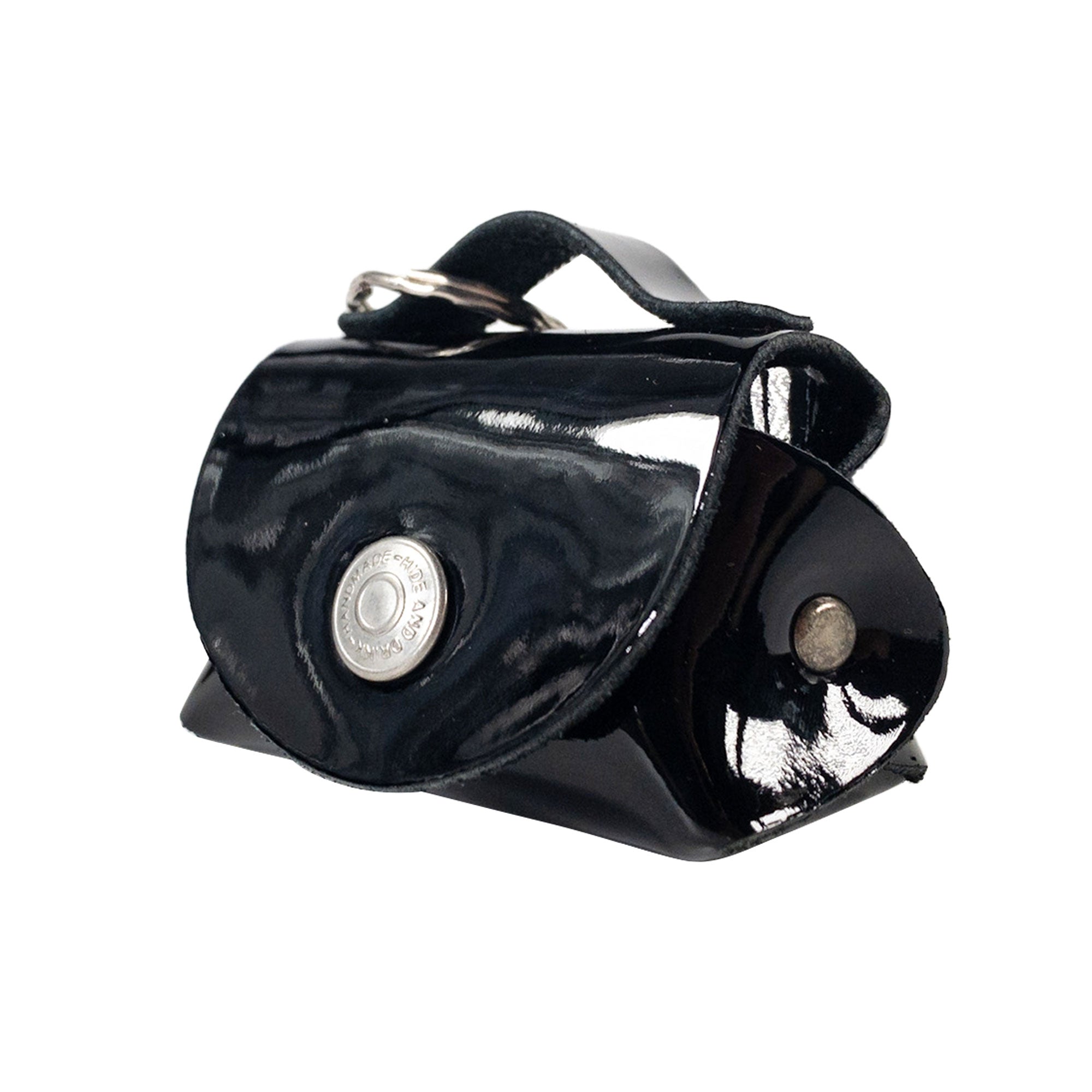 The Tiny Handbag Keychain by Hide & Drink in glossy black leather, showcasing its durability and key ring attachment. This functional keychain is crafted with care as a part of small batch production, highlighting its artisan roots.