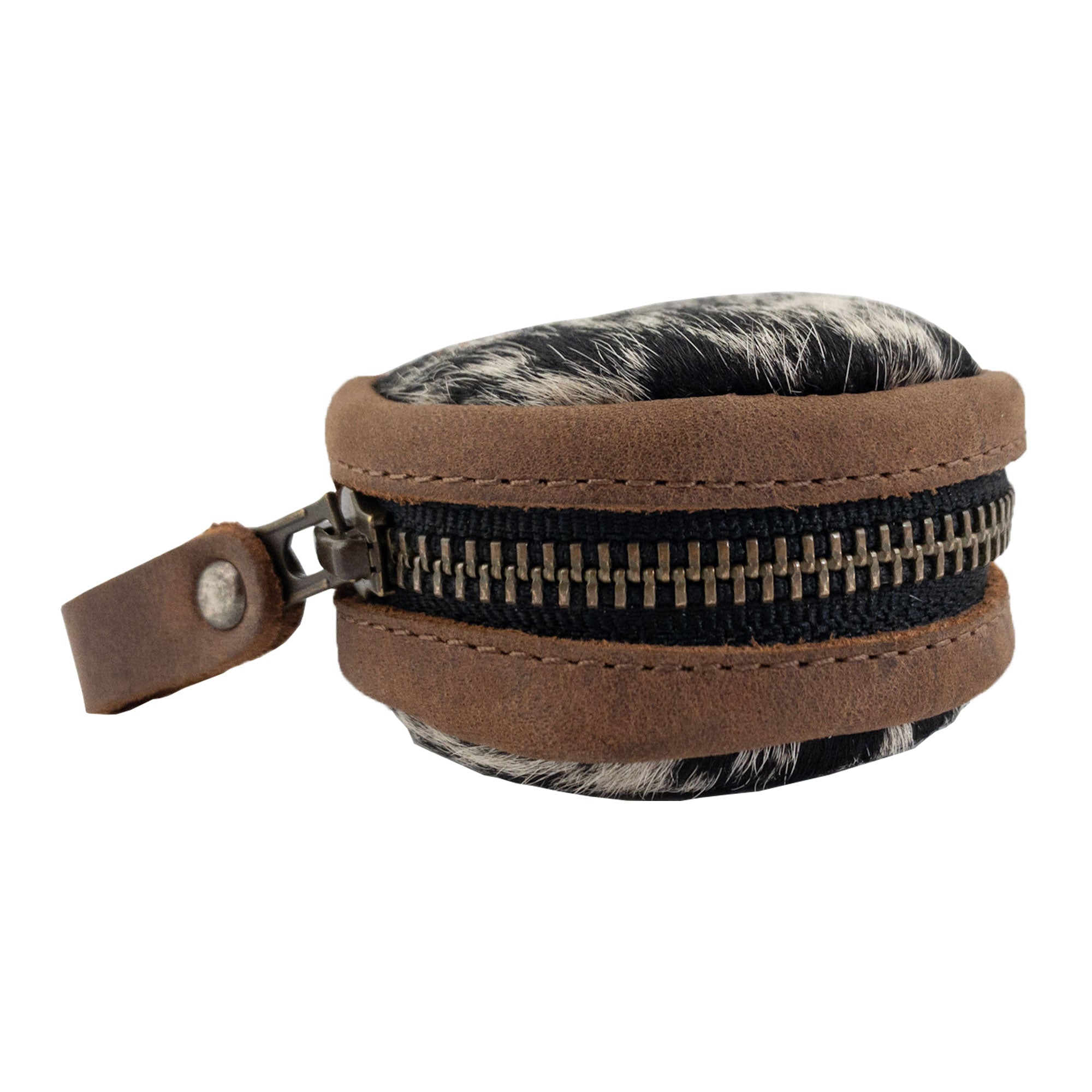 A side view of the Rounded Coin Case by Western Leather Works, showcasing its unique hair-on-hide texture and durable full grain leather zipper. This handmade organizer pouch serves as a perfect carry bag and portable charging cable holder for travel and commuter accessories. Crafted in La Antigua Guatemala, it represents small batch production with meticulous hand cut and hand sewn quality.