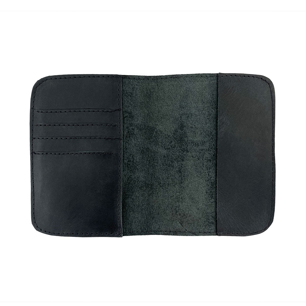 Detailed in-the-hand view of the Hide & Drink Travel Wallet, demonstrating its compact design. This travel wallet serves as a bifold passport case, expertly made from full grain leather in La Antigua Guatemala.