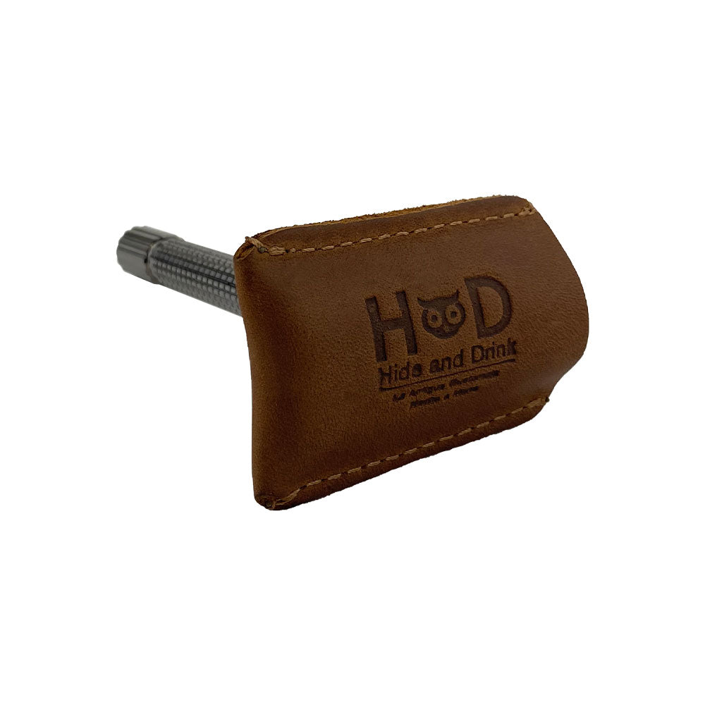 Razor Head Cover from Hide & Drink shown with a double edge safety razor, made from full grain leather. This artisan shaving travel cover is designed to protect your razor head, highlighting small batch production and handmade craftsmanship from La Antigua Guatemala and Oaxaca Mexico.