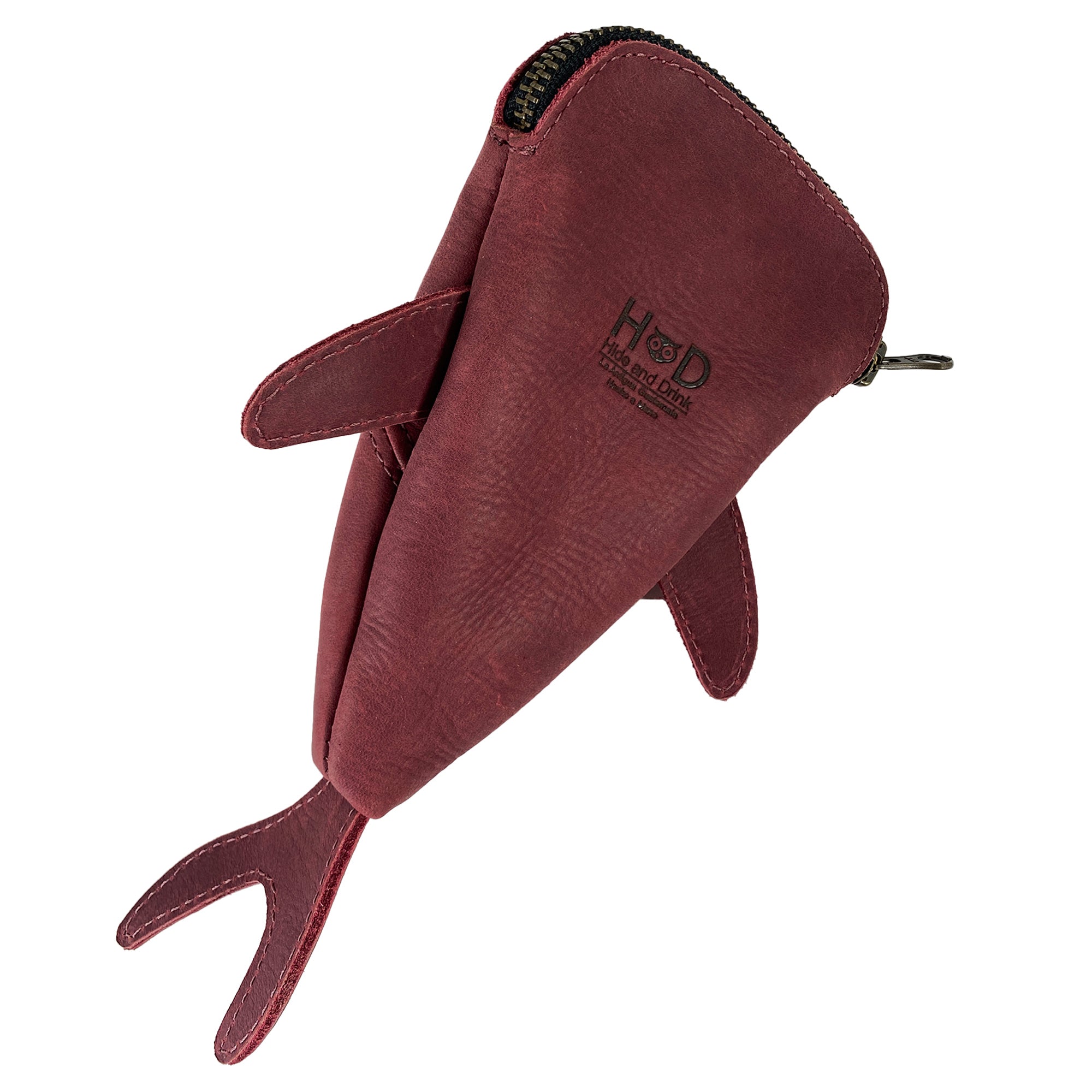 Side perspective of the red Leather Shark Pouch by Hide & Drink, showcasing its bright exterior and zippered closure. This shark shaped case serves as a stylish pencil purse or coin bag and is crafted from premium full grain leather, reflecting artisan craftsmanship from La Antigua Guatemala & Oaxaca Mexico.