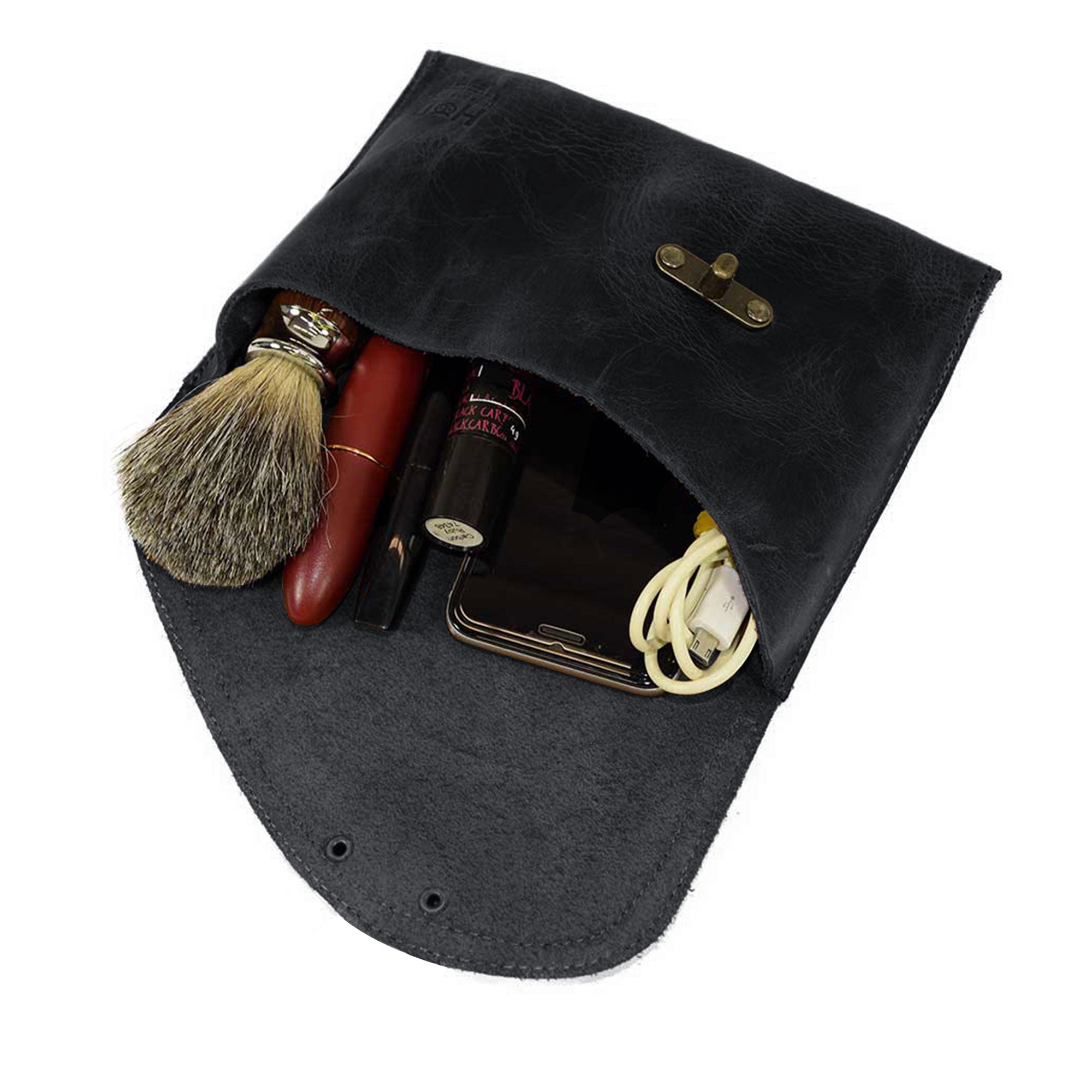 The Petite Vintage Clutch Bag by Hide & Drink, with its interior filled with essentials, demonstrates its practicality as a travel accessory. Crafted from full grain leather and handmade in La Antigua Guatemala & Oaxaca Mexico, it’s a beautiful blend of style and function.