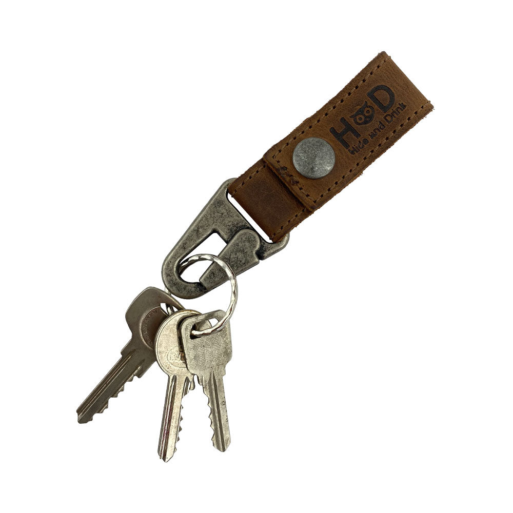 The Hide & Drink Key Ring Holder with keys attached, showcasing its practical design in Full Grain Leather for daily use. This Key Ring Holder is a product of Small Batch Production and Artisan craftsmanship, made Hand Cut and Hand Sewn in La Antigua Guatemala & Oaxaca Mexico.