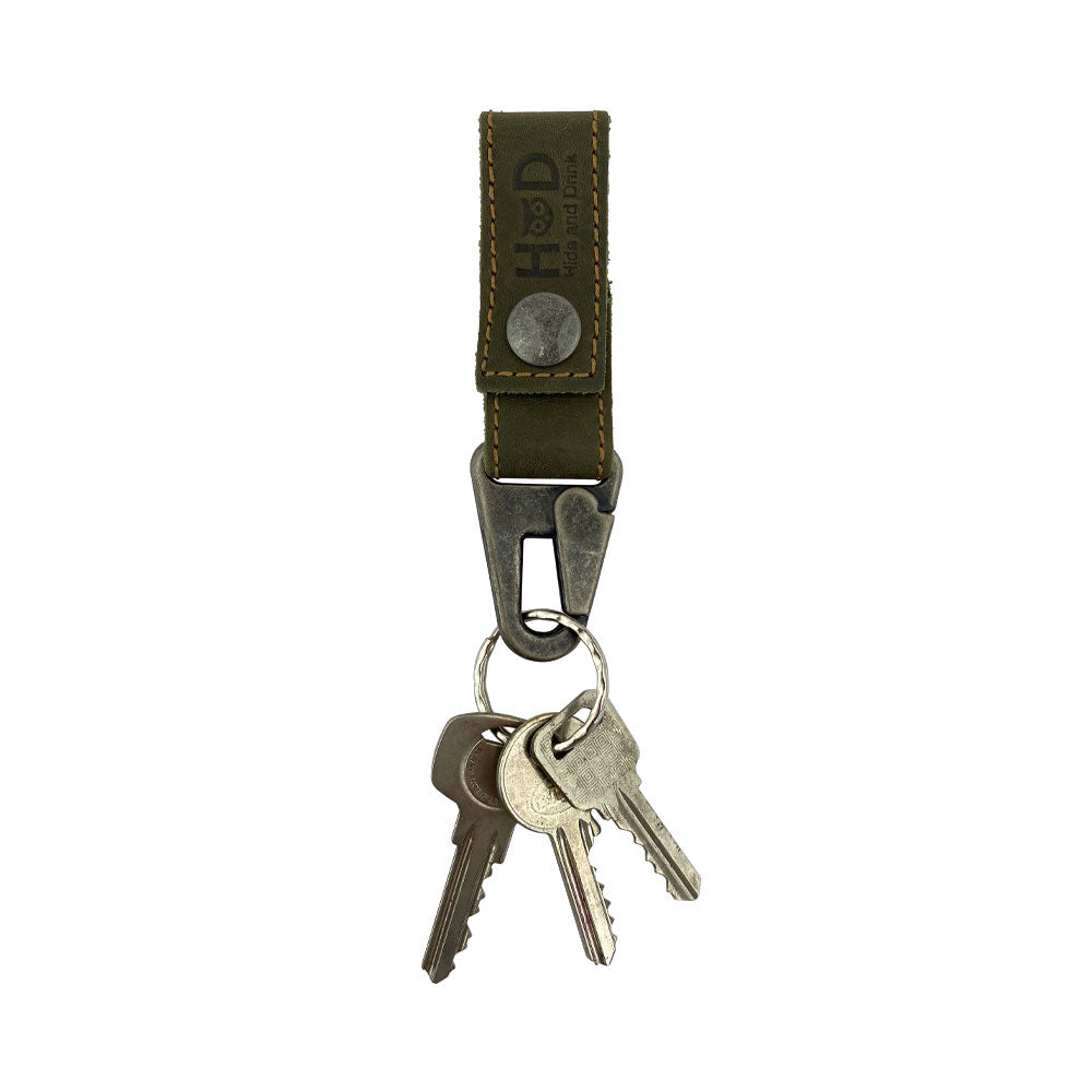 Hide & Drink Key Ring Holder featuring an olive green leather strap, perfect for easy key access. Handmade with Full Grain Leather, this artisan piece emphasizes Small Batch Production, highlighted by its Hand Cut and Hand Sewn features.