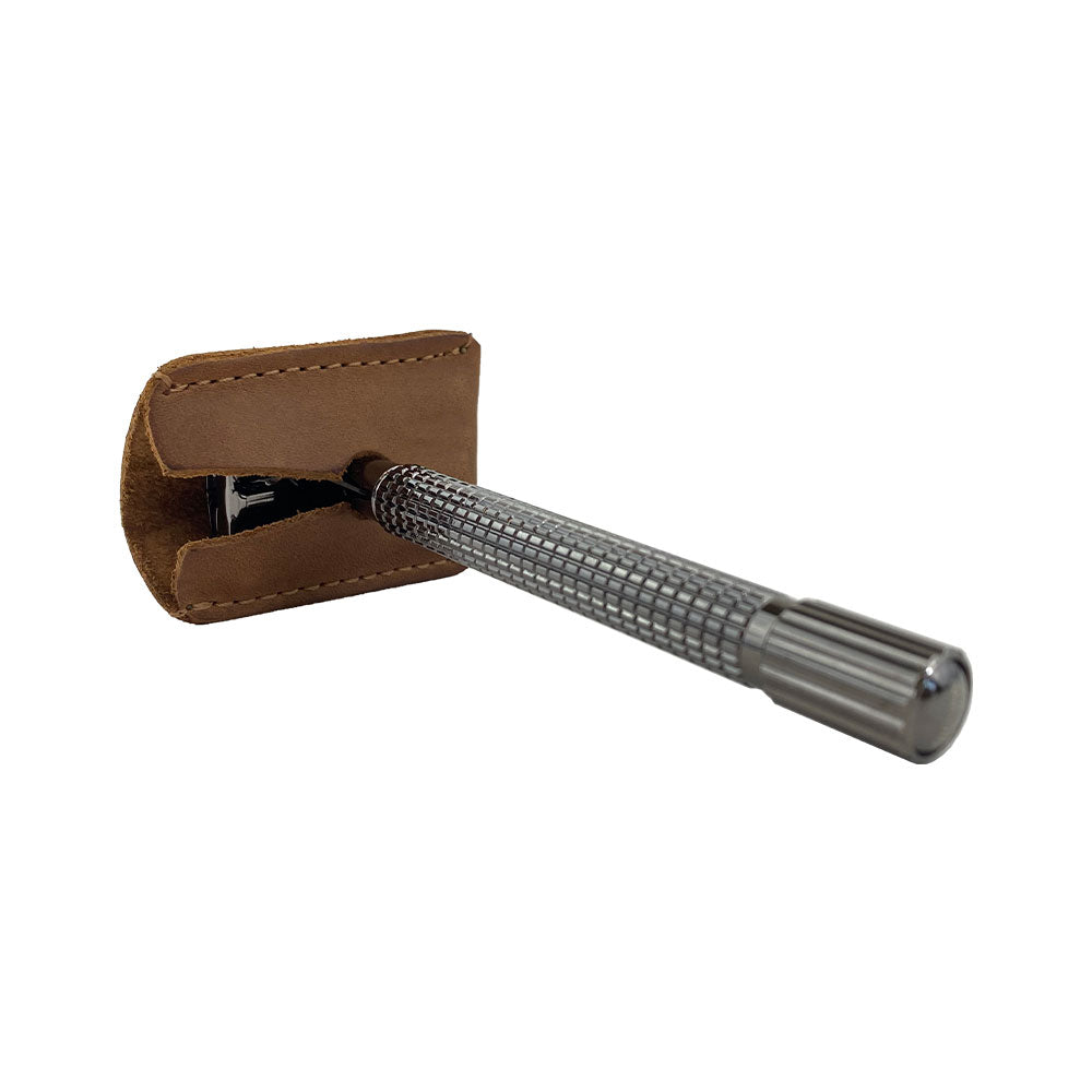 Close-up of Hide & Drink's Razor Head Cover fitting a double edge safety razor, showcasing its full grain leather construction. This protective sheath is an artisan product, emphasizing small batch production, hand cut, hand sewn design, and fire branding from La Antigua Guatemala and Oaxaca Mexico.