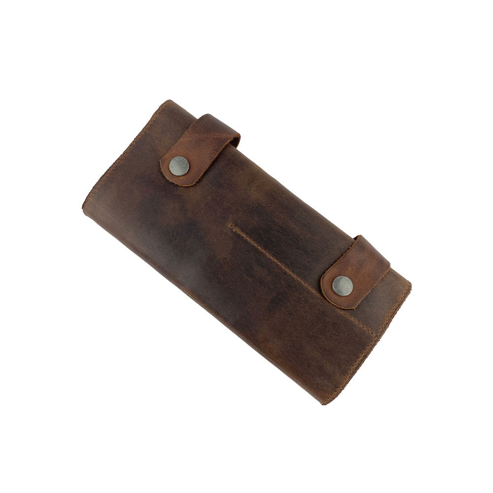 Hide & Drink presents its Barber Tool Roll featuring a Snap Tool Roll Up Bag with 14 Slots, designed for easy organization of scissors & screwdrivers. Constructed from high-quality Full Grain Leather, this portable carry case embodies StockyardX's commitment to small batch production and artisan craftsmanship, hand cut, hand sewn, and fire branded in La Antigua Guatemala & Oaxaca Mexico.