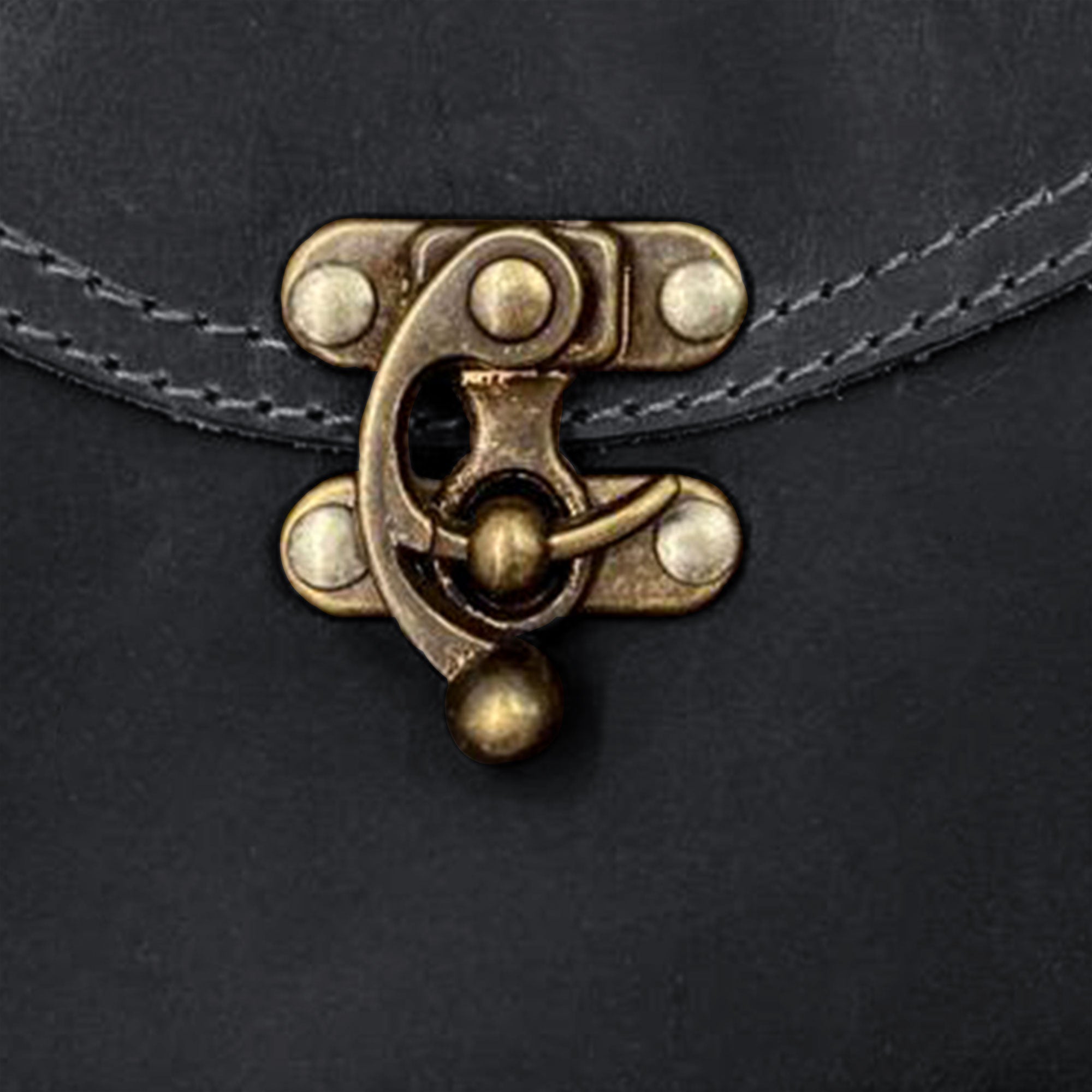 Close-up of the brass clasp detail on the Petite Vintage Clutch Bag by Hide & Drink. This carefully crafted evening bag made from full grain leather showcases unique features that celebrate artisan workmanship from La Antigua Guatemala & Oaxaca Mexico.