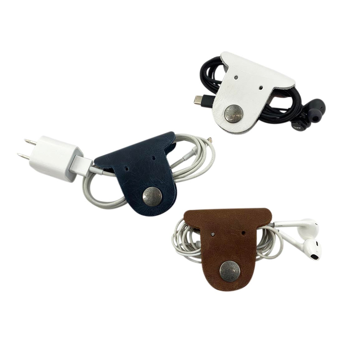 Multicolor Dog Cord Keeper (3 Pack) by Taco Dog illustrating an organized bunch of cables using stylish dog-shaped leather cord keepers, making travel easier and tidier. Dog Cord Keeper - Wrap Up Your Cables, Earbuds, Headphones, Chargers - Clip The Straps Together for Easy Management and Travel - 3-Pack, Full Grain Leather, StockyardX, Small Batch Production, Hand Cut, Hand Sewn, Fire Branded, Artisan, Handmade in La Antigua Guatemala & Oaxaca Mexico.