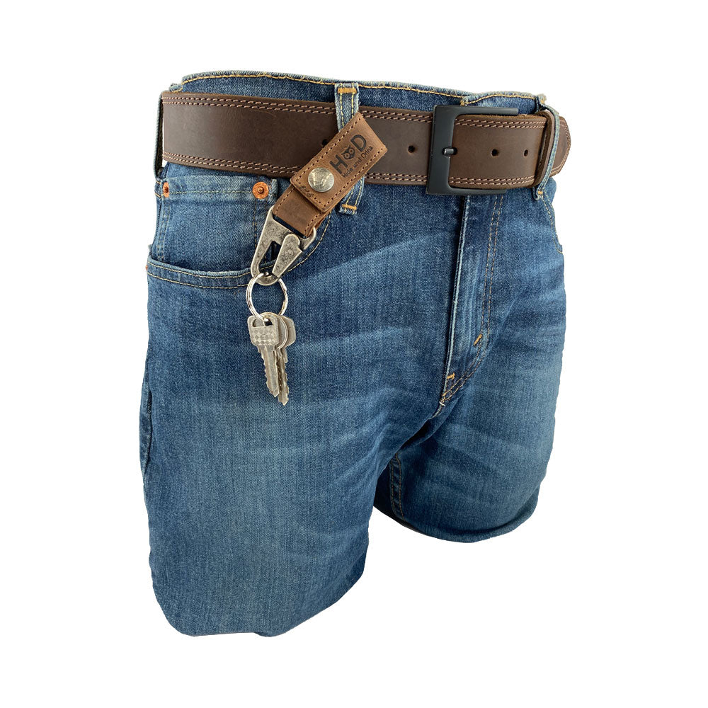 A view of the Hide & Drink Key Ring Holder attached to jeans, demonstrating its practical use and rustic Full Grain Leather material. This Key Ring Holder emphasizes Small Batch Production and is Hand Cut and Hand Sewn by artisans in La Antigua Guatemala & Oaxaca Mexico.