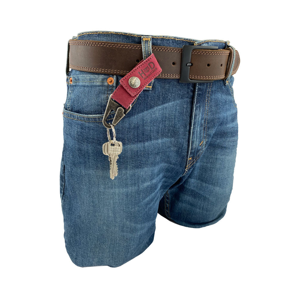 Another view of the Key Ring Holder from Hide & Drink, highlighting its attachment to denim shorts with keys hanging, showcasing practicality and style. Key Ring Holder, Full Grain Leather, StockyardX, Small Batch Production, Hand Cut, Hand Sewn, Fire Branded, Artisan, Handmade in La Antigua Guatemala & Oaxaca Mexico.