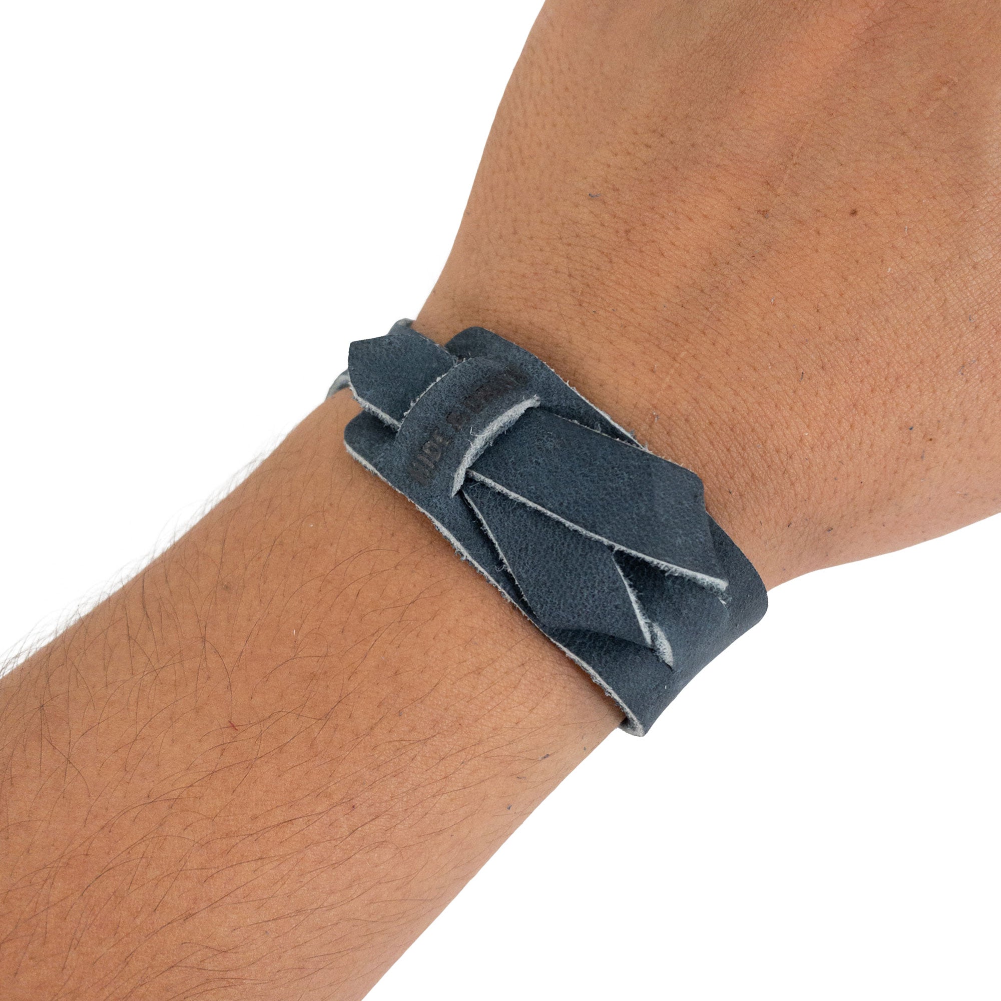 Hide & Drink’s Minimalist Wristband in navy worn on wrist, exemplifying its stylish design and comfort. Made from full grain leather, this adjustable cuff is a rustic bracelet reflecting StockyardX's artisan craftsmanship from La Antigua Guatemala.
