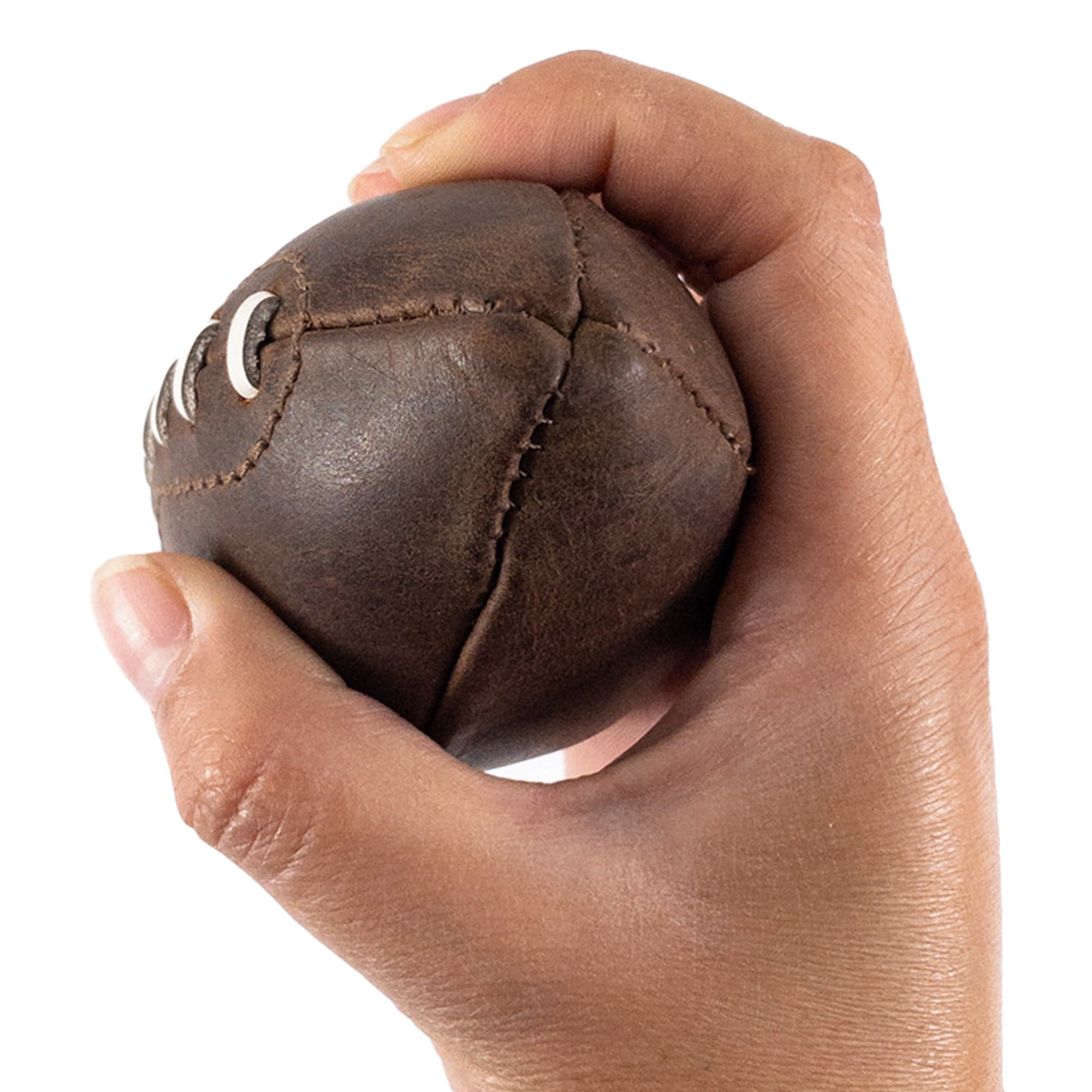 Close-up of a hand holding a Mini American Football by Hide & Drink, highlighting the intricacies of its hand sewn seams and quality leather. This small memorabilia piece embodies craftsmanship from Small Batch Production, making it a perfect gift or decoration.