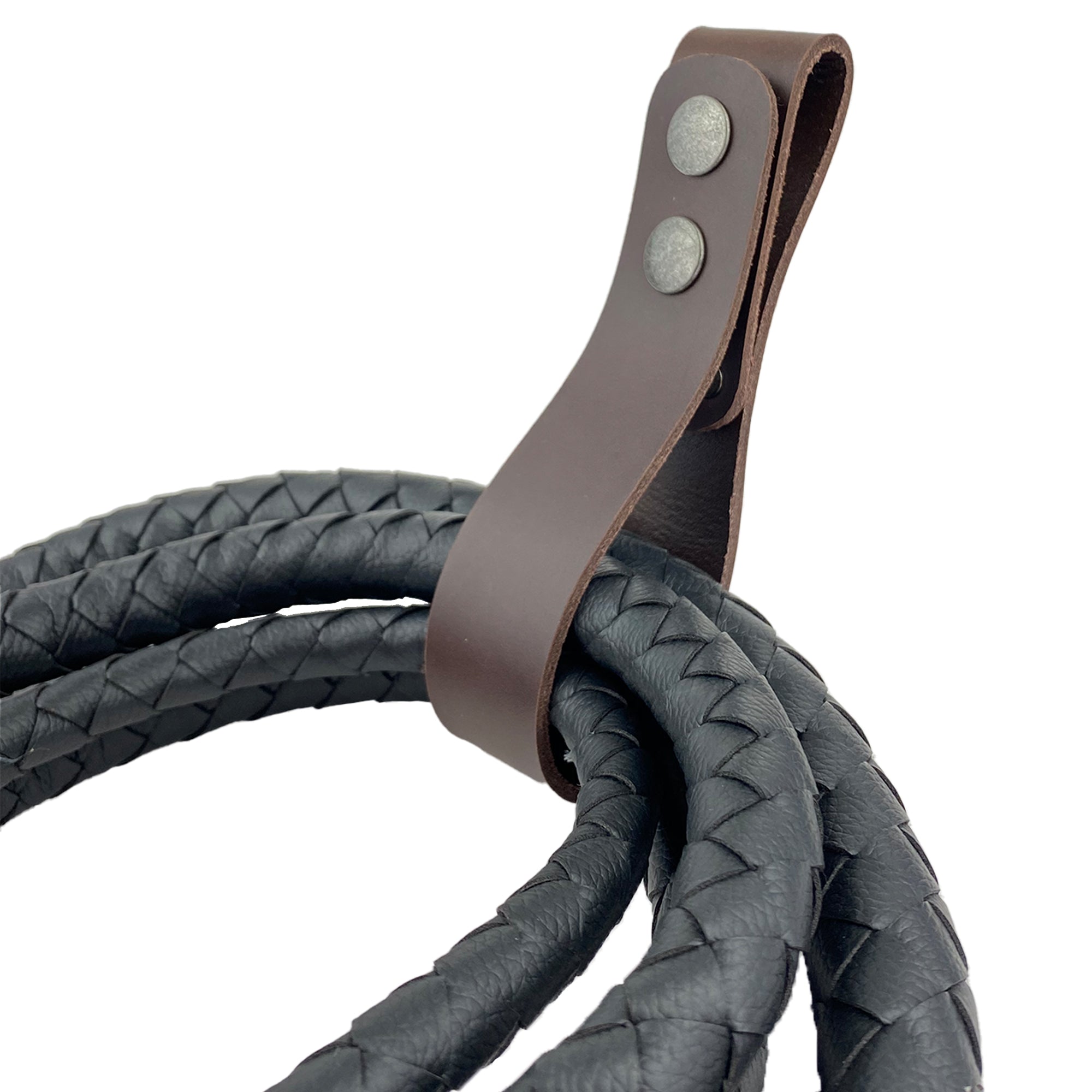 Thick Whip Holder by Hide & Play, attached to a braided whip, illustrating its function as a whip holster made from thick full grain leather. This belt loop bullwhip holder is ideal for pastoral tools, showcasing the art of small batch production with hand cut, hand sewn features, fire branded, and handcrafted in La Antigua Guatemala & Oaxaca Mexico.