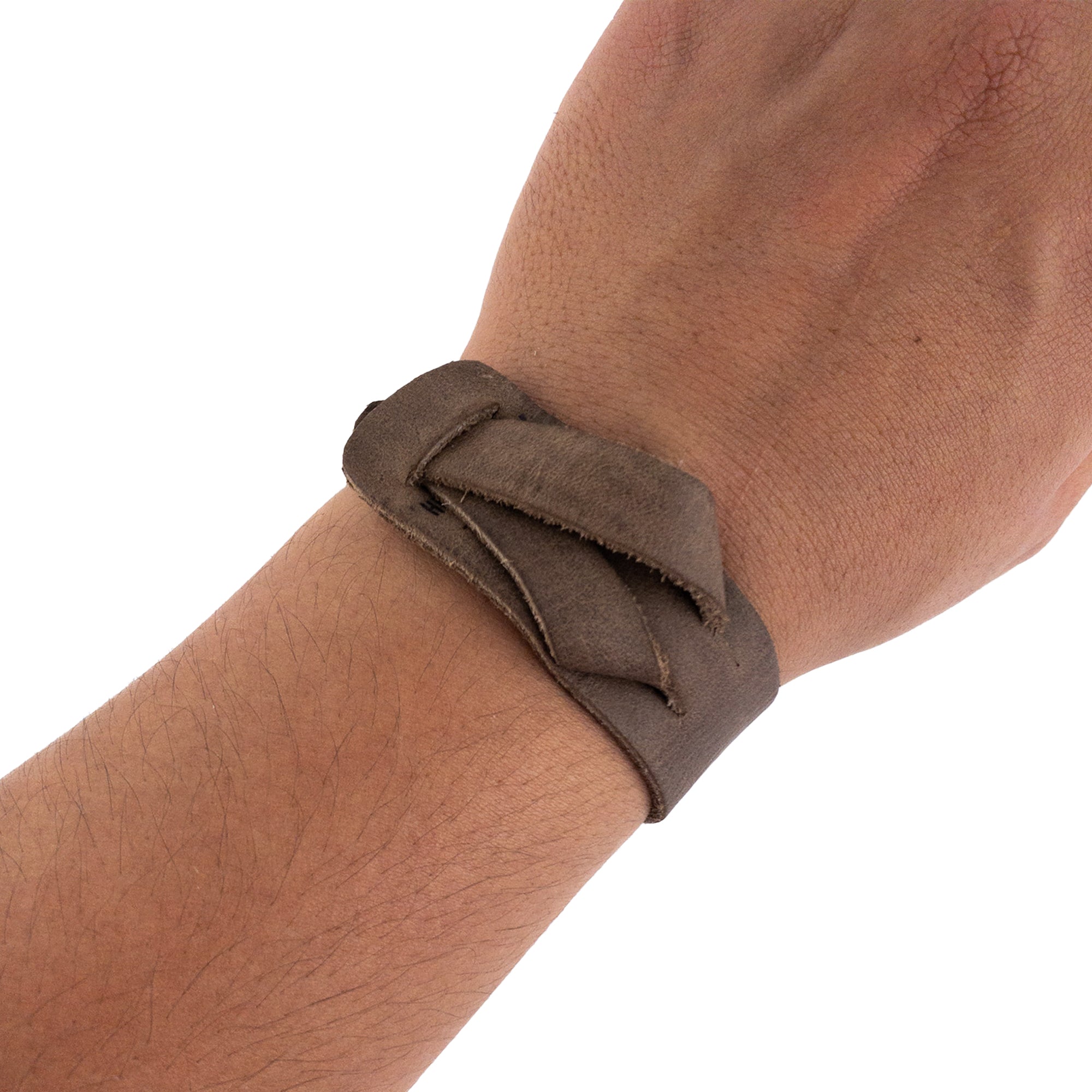 Hide & Drink's Minimalist Wristband worn on the wrist, capturing its stylish design in full grain leather. This rustic cuff is adjustable and comfortable, showcasing the craftsmanship of artisans from La Antigua Guatemala. A bracelet by StockyardX, emphasizing handmade quality through small batch production.