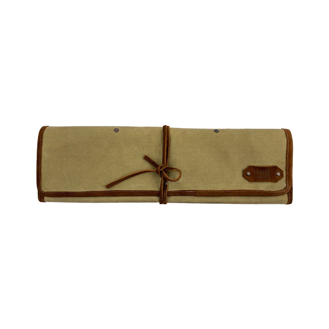 Hide & Drink Knife Roll (5 Pockets) displayed with a set of culinary tools, crafted from Full Grain Leather. This Chef Knife Bag serves as a portable carrying case for knives, epitomizing quality artisan craftsmanship with handmade details, small batch production, and hand cut and hand sewn practices.