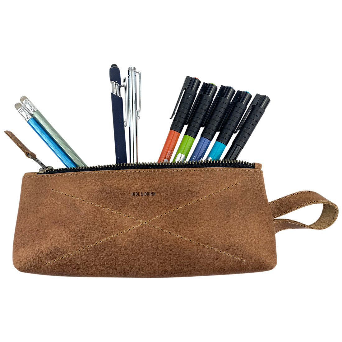 Hide & Drink's X Stitched Case, showcasing intricate hand stitching, is perfect for stationery and travel essentials. Made from full grain leather, this artisan-managed product reflects the craftsmanship of La Antigua Guatemala and Oaxaca, Mexico.