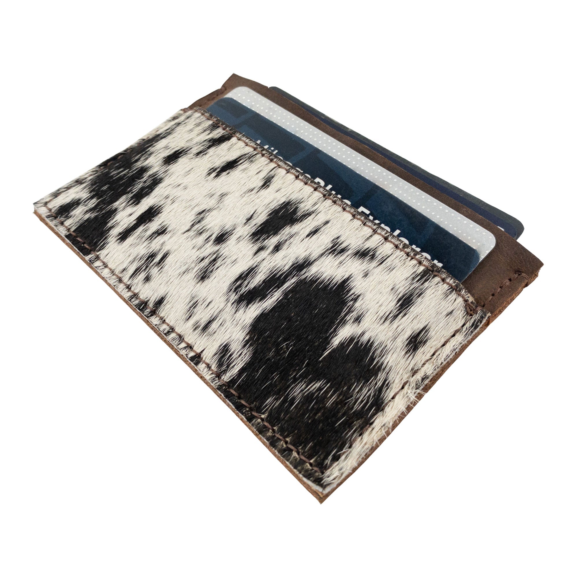 Top view of the Western Leather Works Double Card Wallet filled with cards. This handcrafted product is a perfect example of compact storage, functioning well as an ID holder or travel accessory. Made with care in La Antigua Guatemala using hair-on-hide full grain leather, emphasizing artisan craftsmanship.