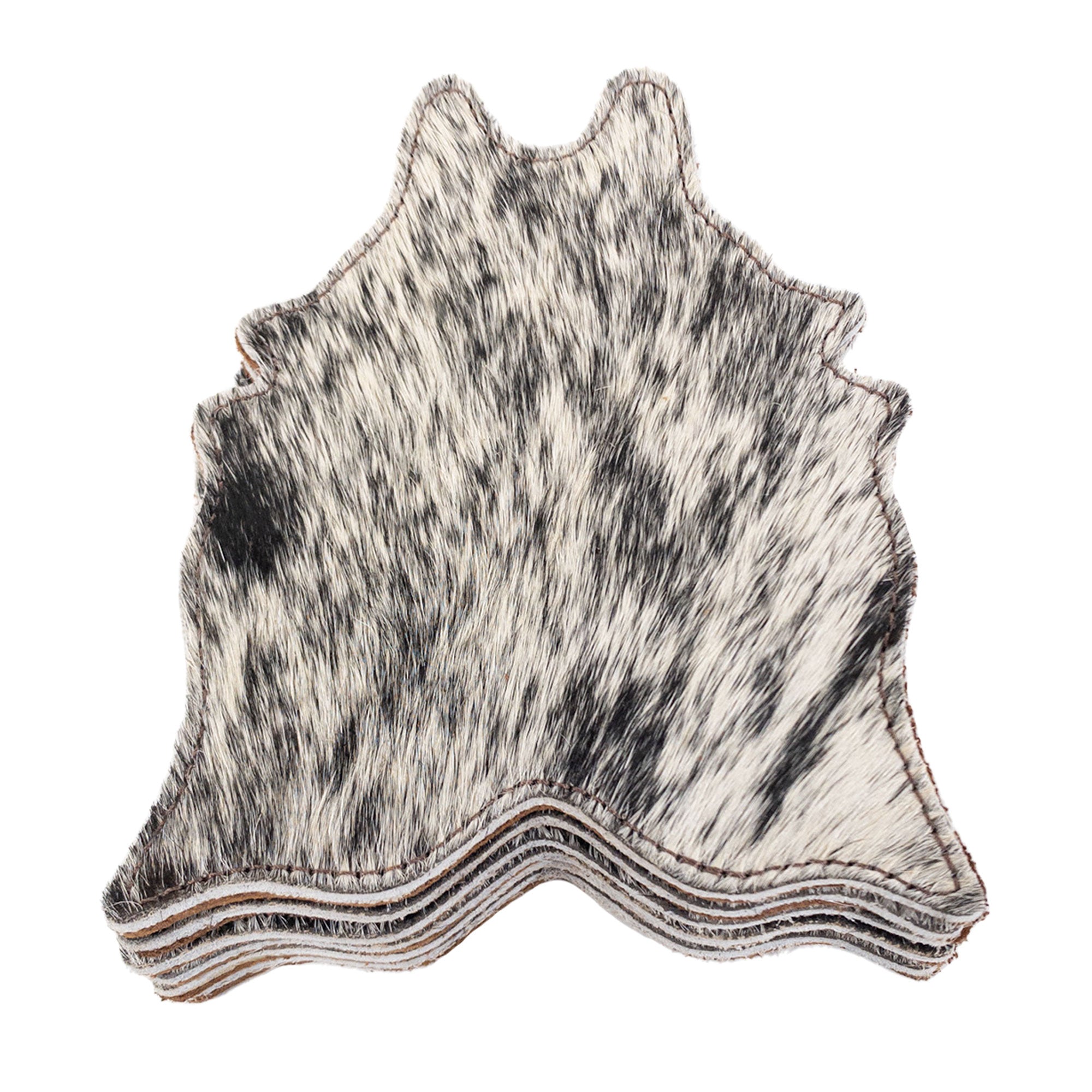 Stacked view of Cowhide Shape Set of 6 Coasters from Western Leather Works featuring a black and white design. Made from Hair On Hide Full Grain Leather, these coasters are handcrafted in La Antigua Guatemala & Oaxaca Mexico, perfect for drinks and showcasing small batch production.