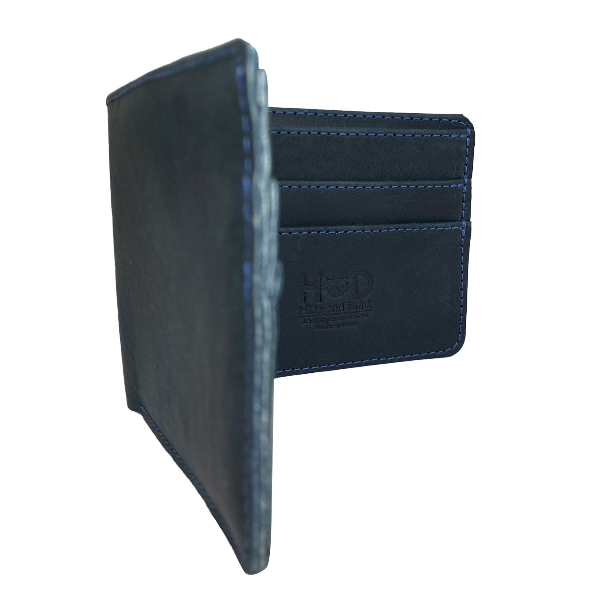 Hide & Drink's blue Bifold Wallet next to a Stockyard Exchange card, showcasing the artisan aspect of the product. This Slim Bifold Wallet acts as a classic billfold for easy storage of money and cards, making a stylish travel accessory handcrafted from full grain leather in La Antigua Guatemala & Oaxaca Mexico.
